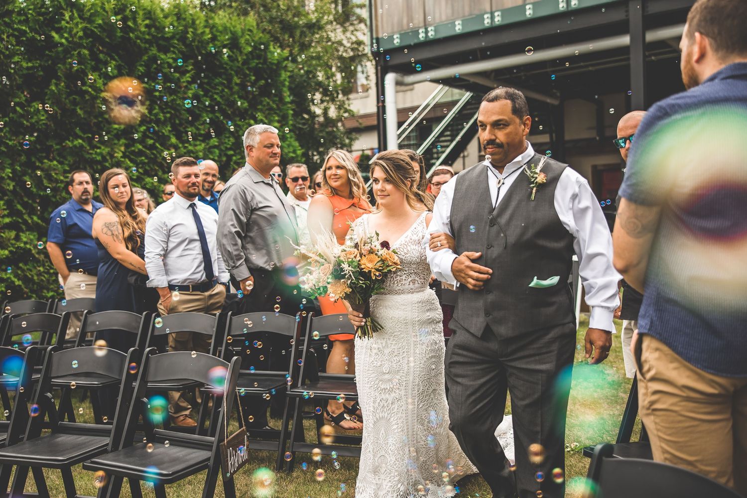 Wedding ceremony candid moments captured at outdoor venue with natural lighting.