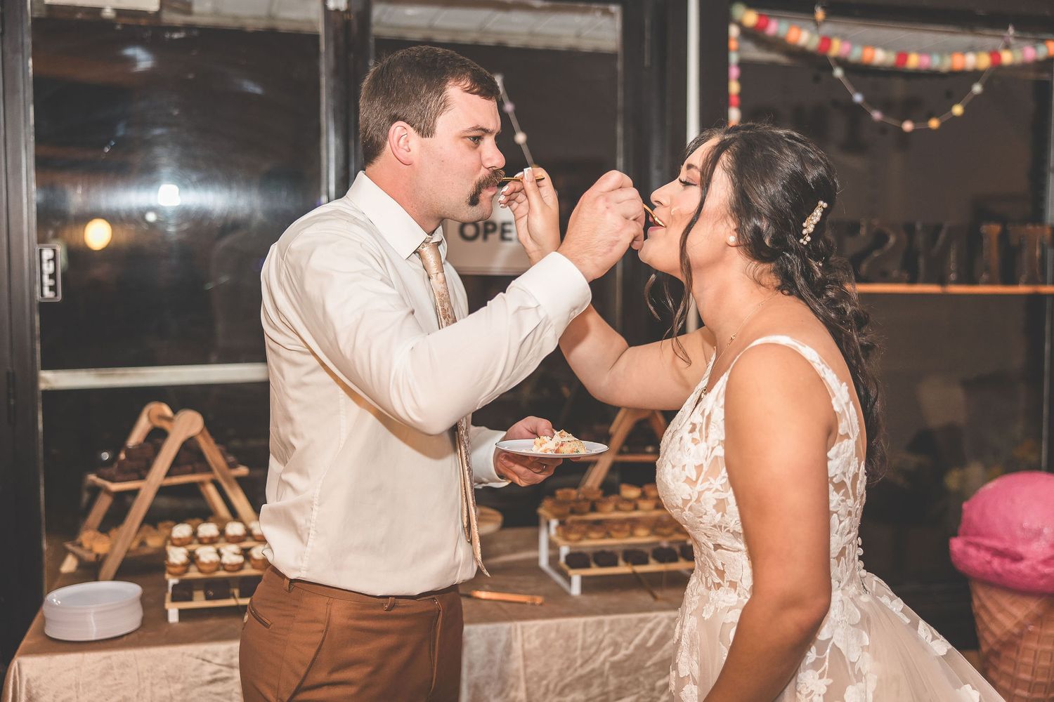 Wedding reception scene with string lights and couples sharing intimate moments.