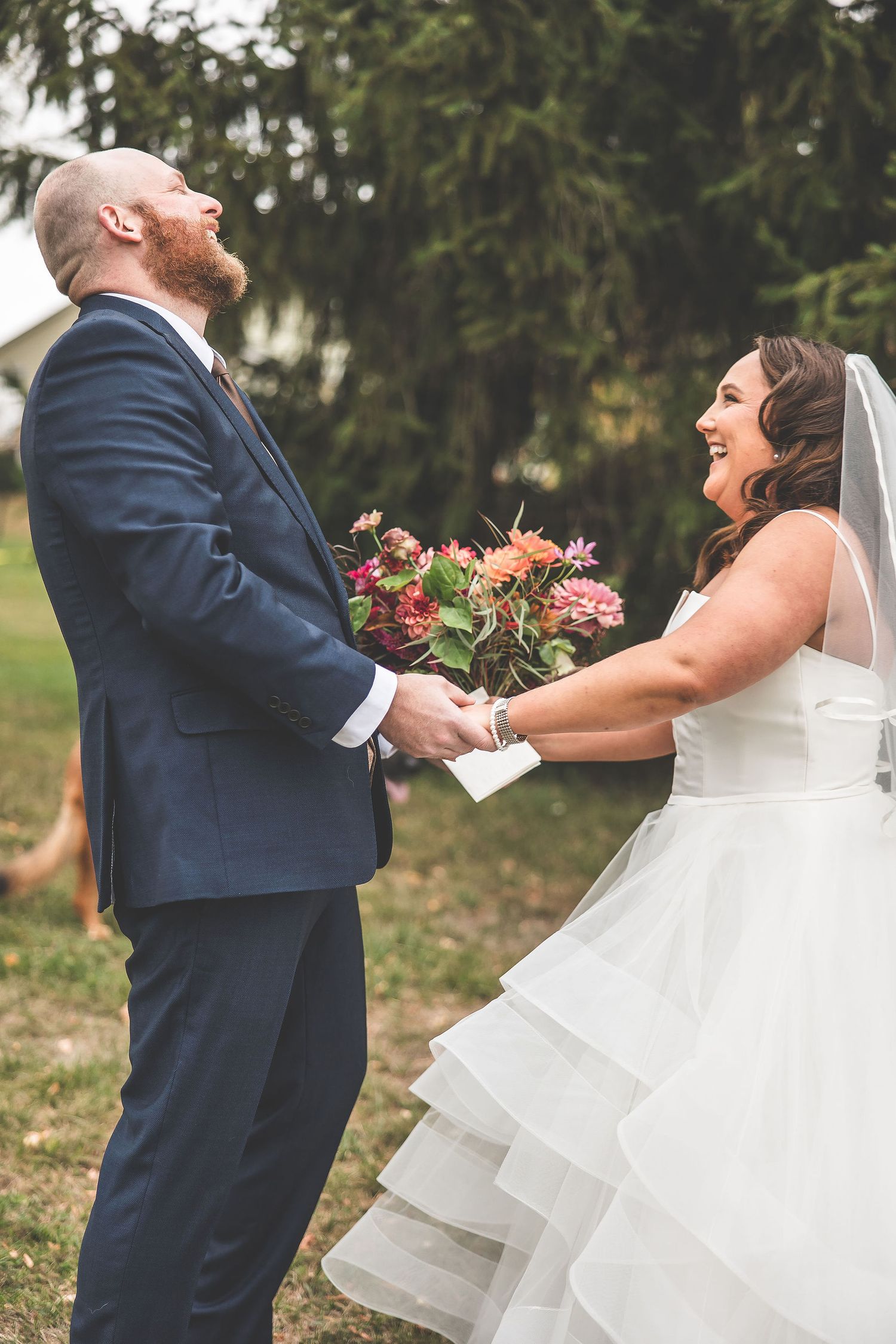 A joyful wedding moment captured as the couple laughs together during their first look.