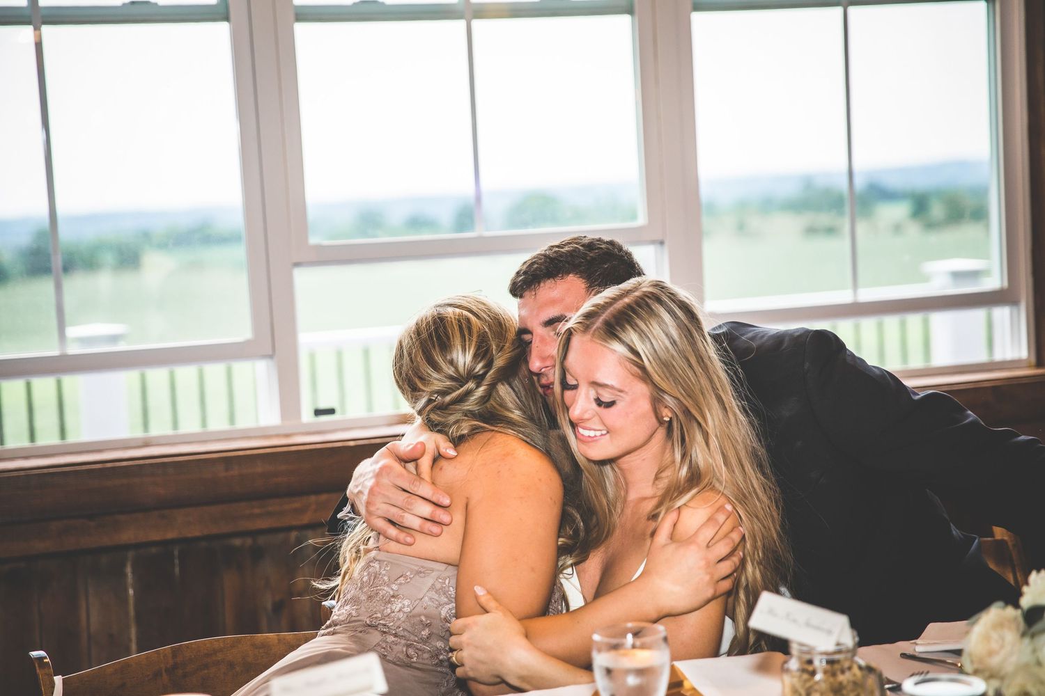 Tender moment shared between wedding guests during reception celebration.