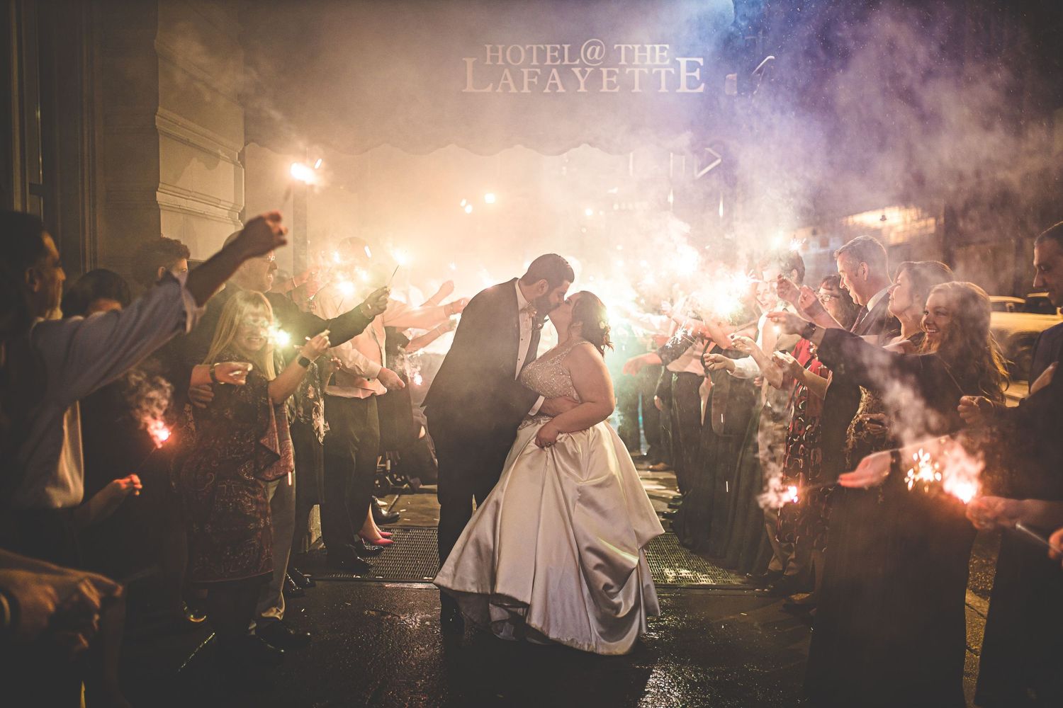 Wedding celebration at night with sparklers creating magical light trails in the darkness.
