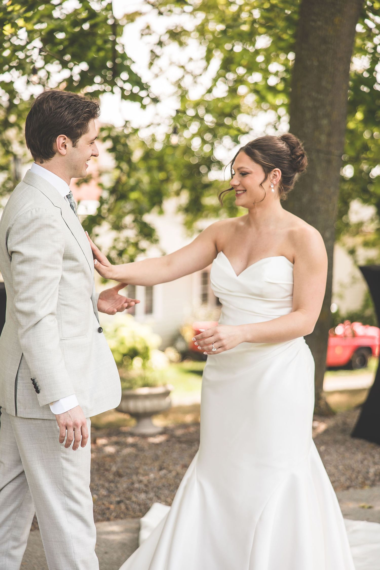 Joyful wedding couple sharing playful moments on a garden path surrounded by greenery.