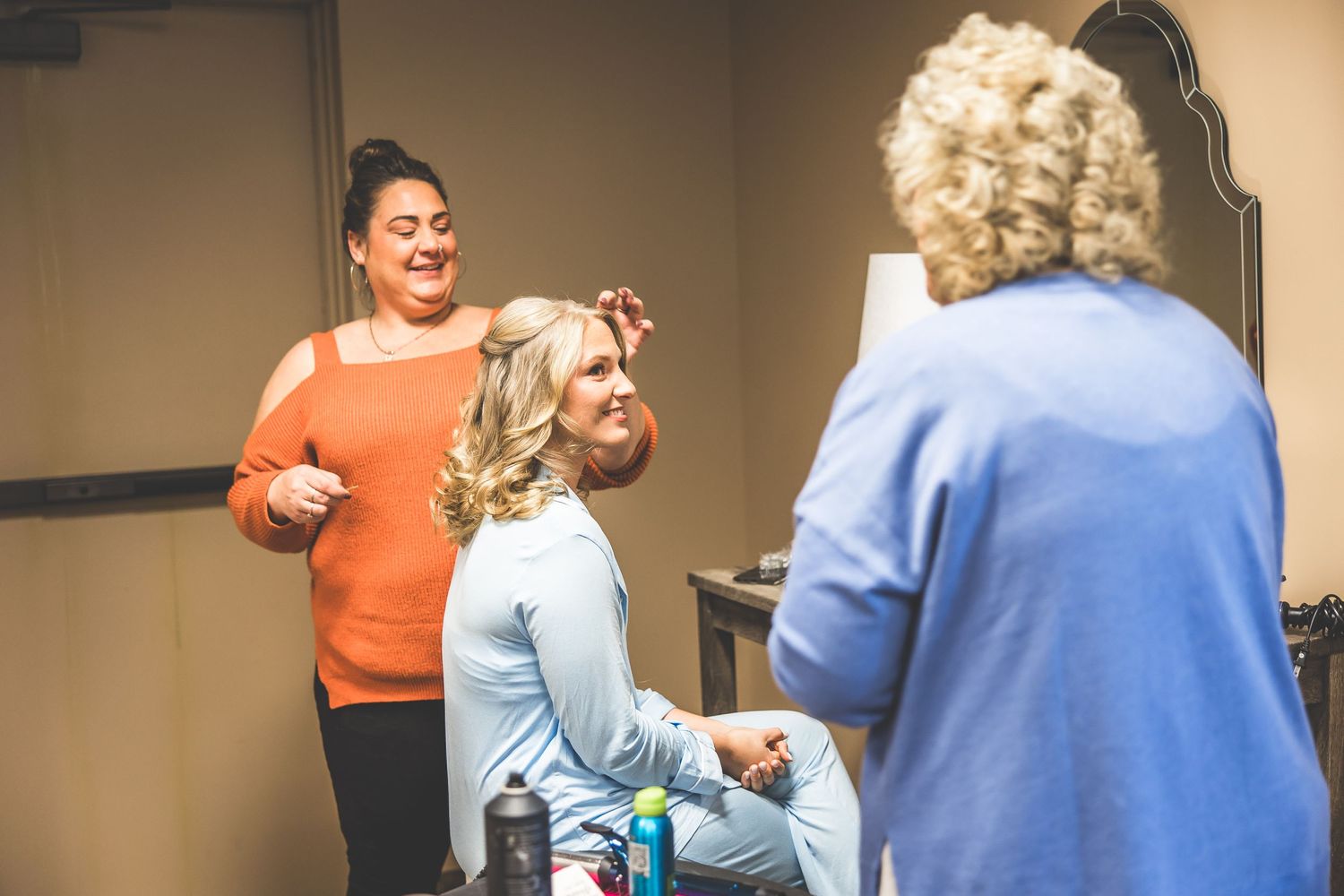 Wedding preparation scene with stylists working in a dressing room.