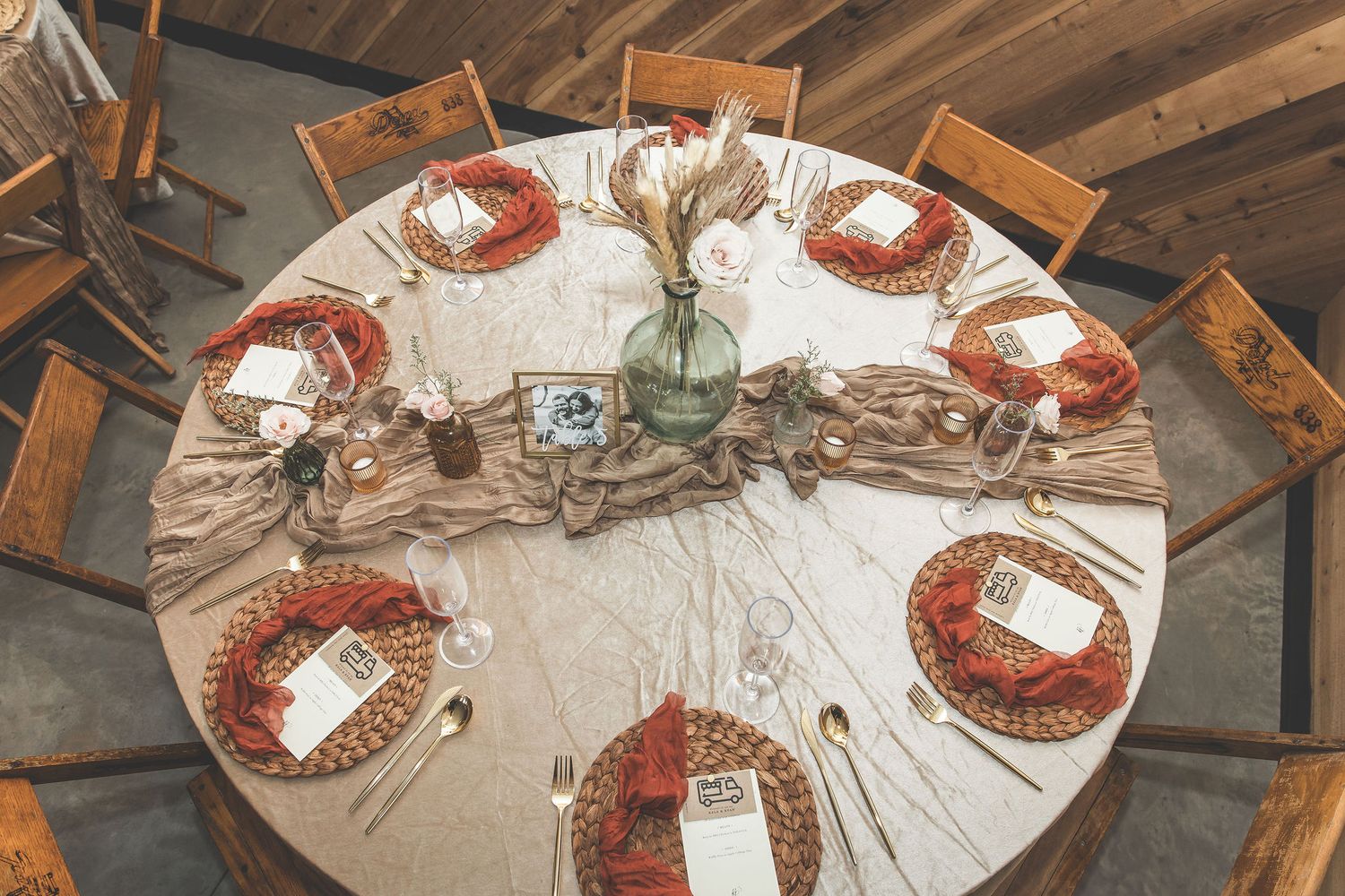 Overhead view of circular wedding reception tables with white tablecloths and place settings.