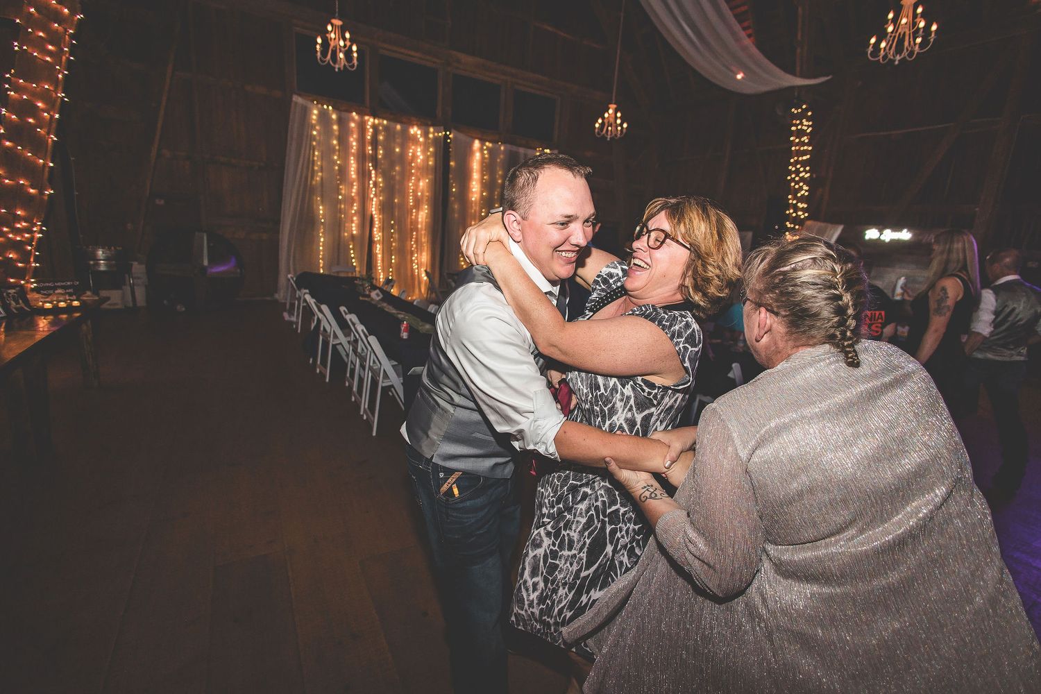 Wedding reception dance floor moments captured in a beautifully lit rustic barn venue.