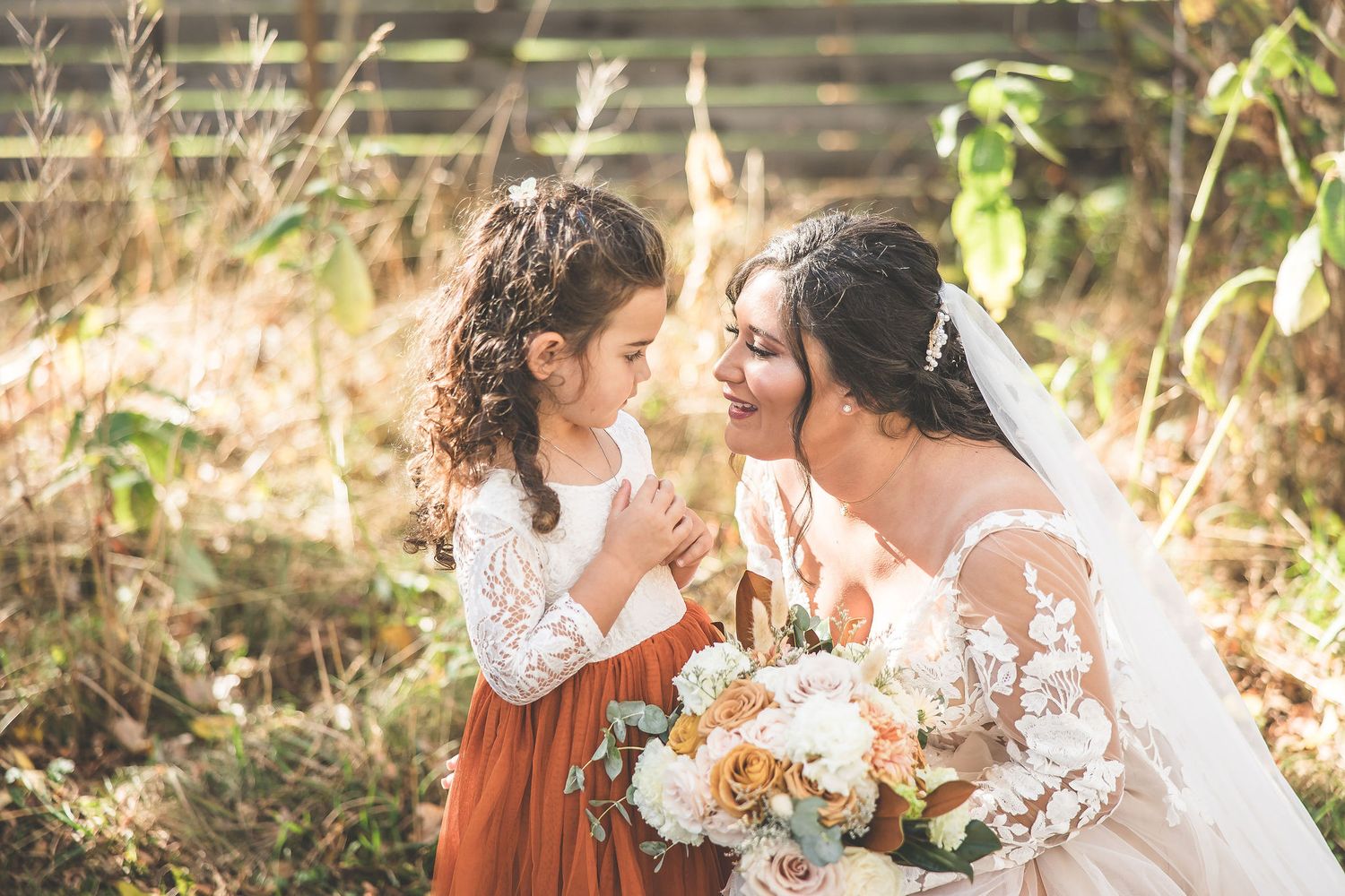 Romantic wedding photography captures intimate moments in natural autumn setting.