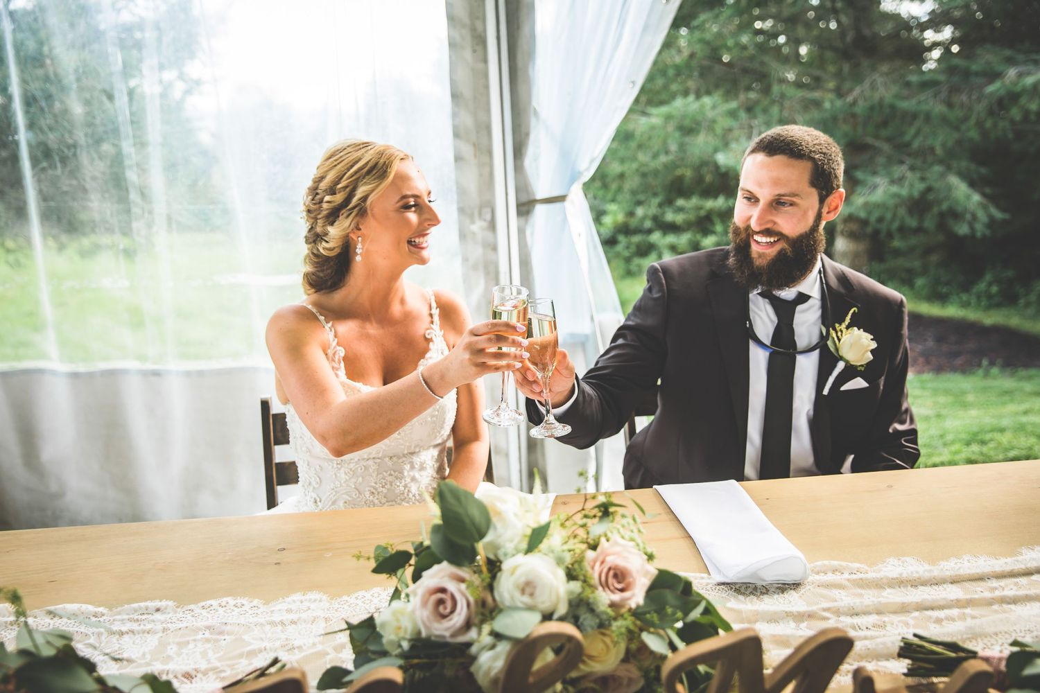 Wedding reception celebration with guests dancing and mingling under tent.