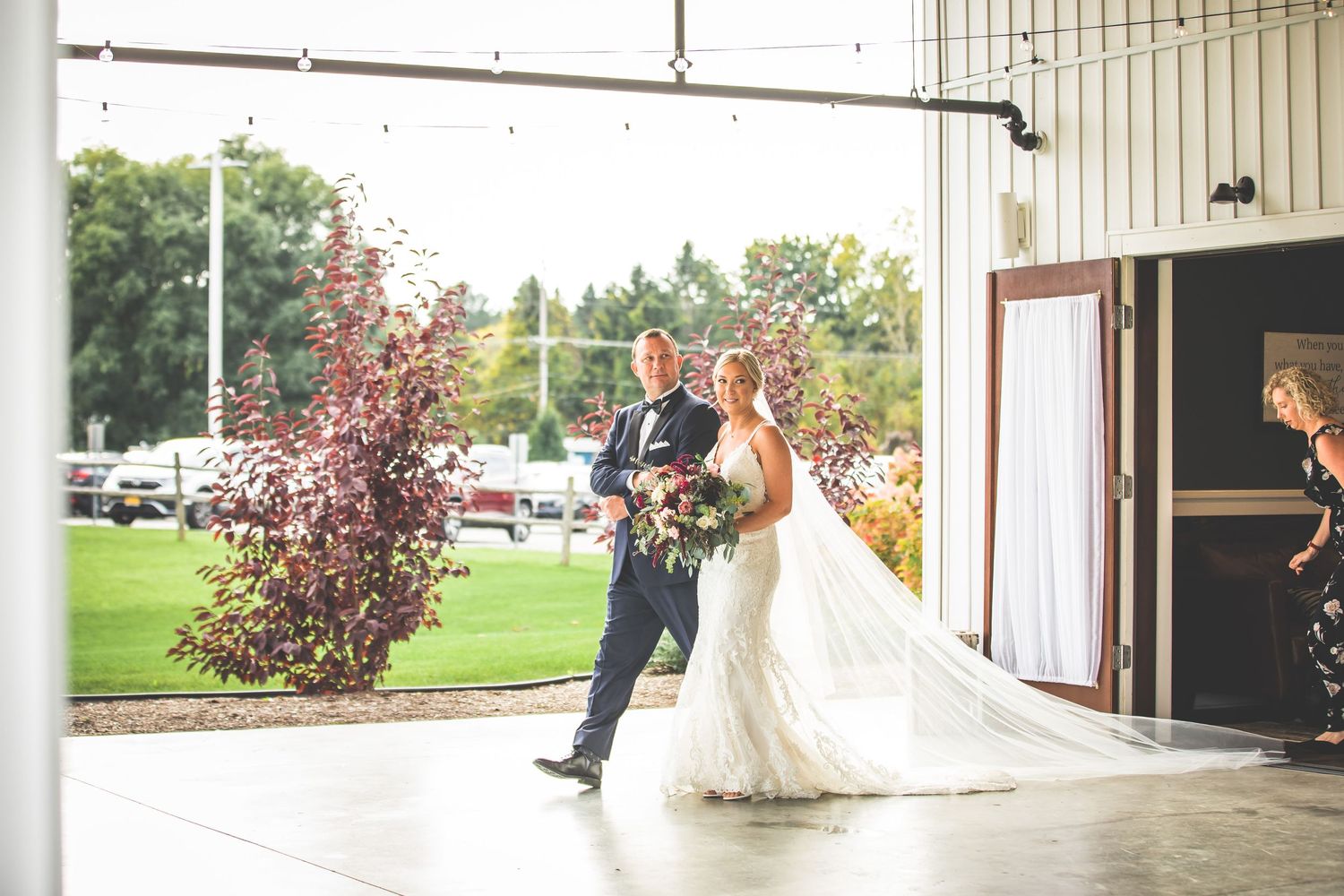 Wedding ceremony taking place in an elegant rustic venue with wooden beams and natural lighting.