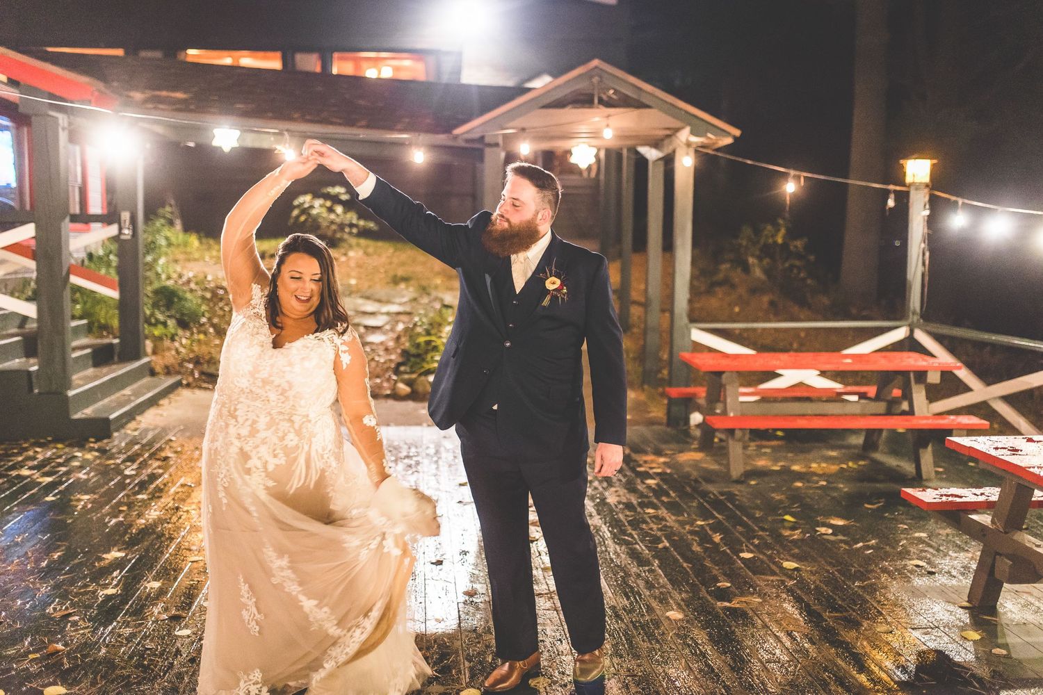 Outdoor evening wedding reception with string lights and decorative elements creating magical atmosphere.