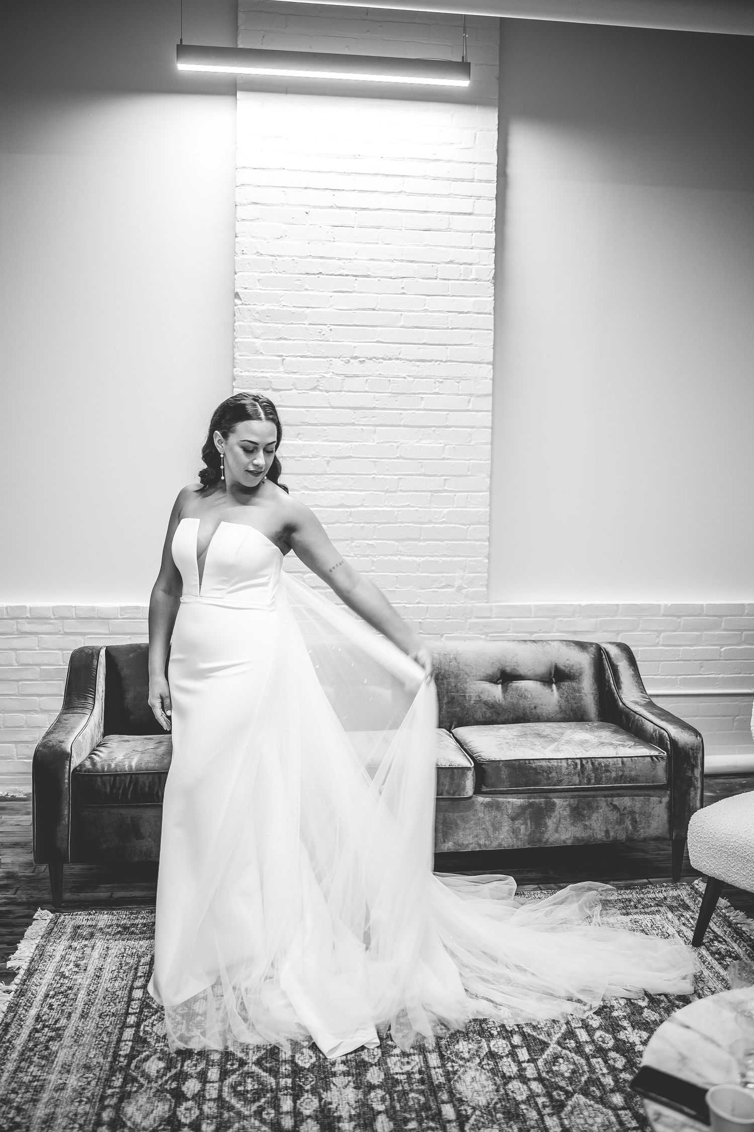 Artistic black and white portrait of person in flowing wedding gown.