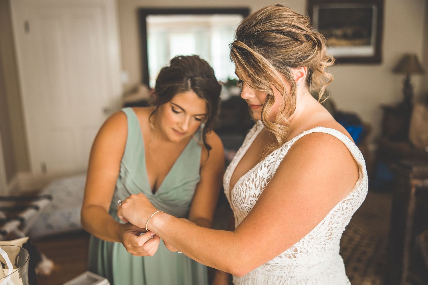 Final adjustments being made to a white lace wedding gown during preparation.