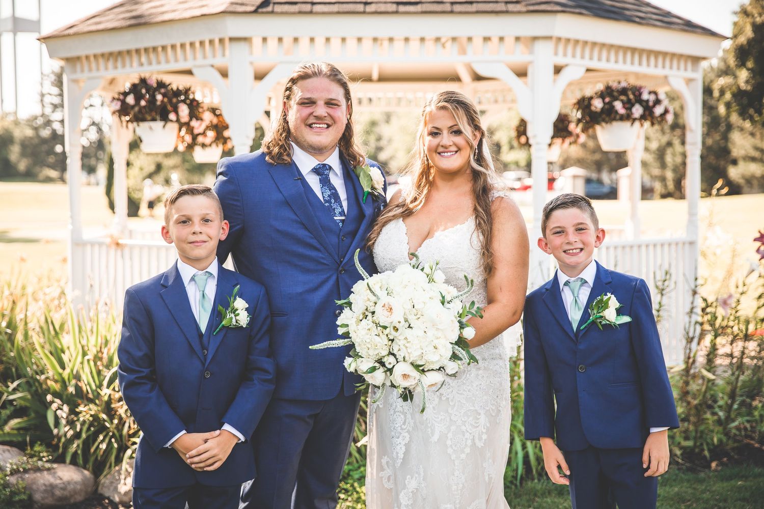 Wedding party in navy blue and white attire posing outside a classic building.