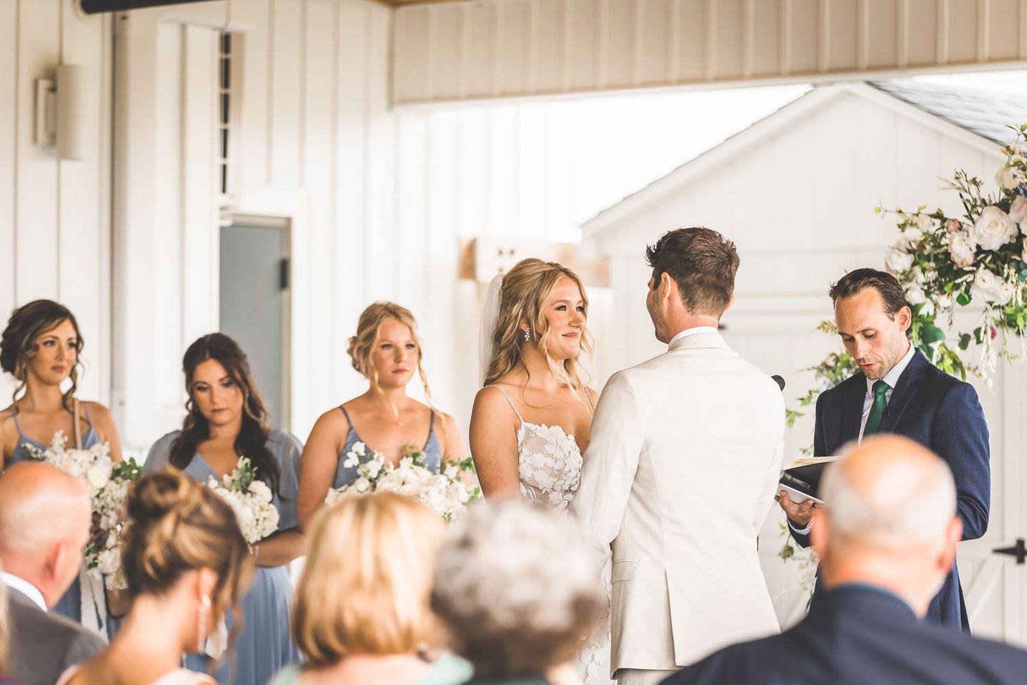 Wedding ceremony in progress with guests seated in bright venue.