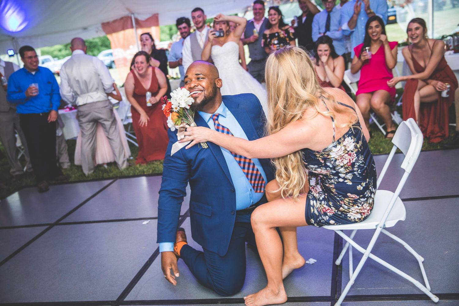Large group of wedding guests participating in a choreographed dance routine at an indoor reception.