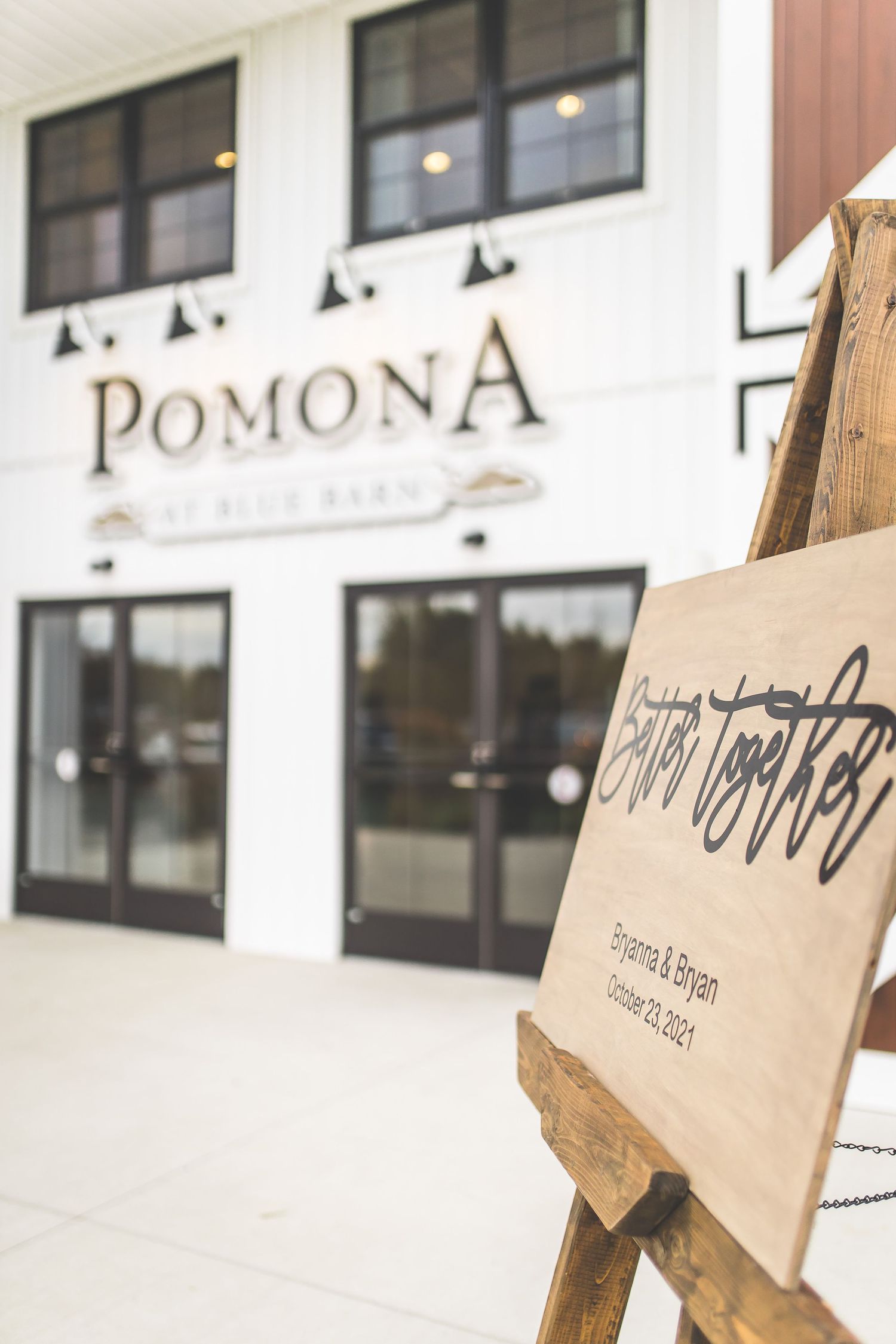 Modern white building exterior with Pomona signage and wooden decor elements.
