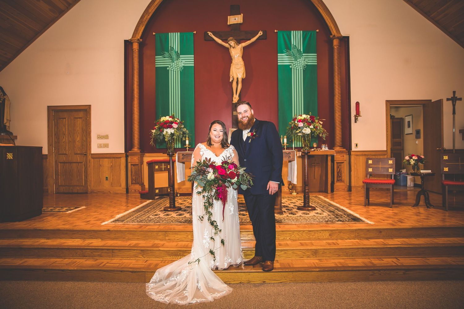 Church sanctuary with wooden pews and green crosses during a wedding ceremony.