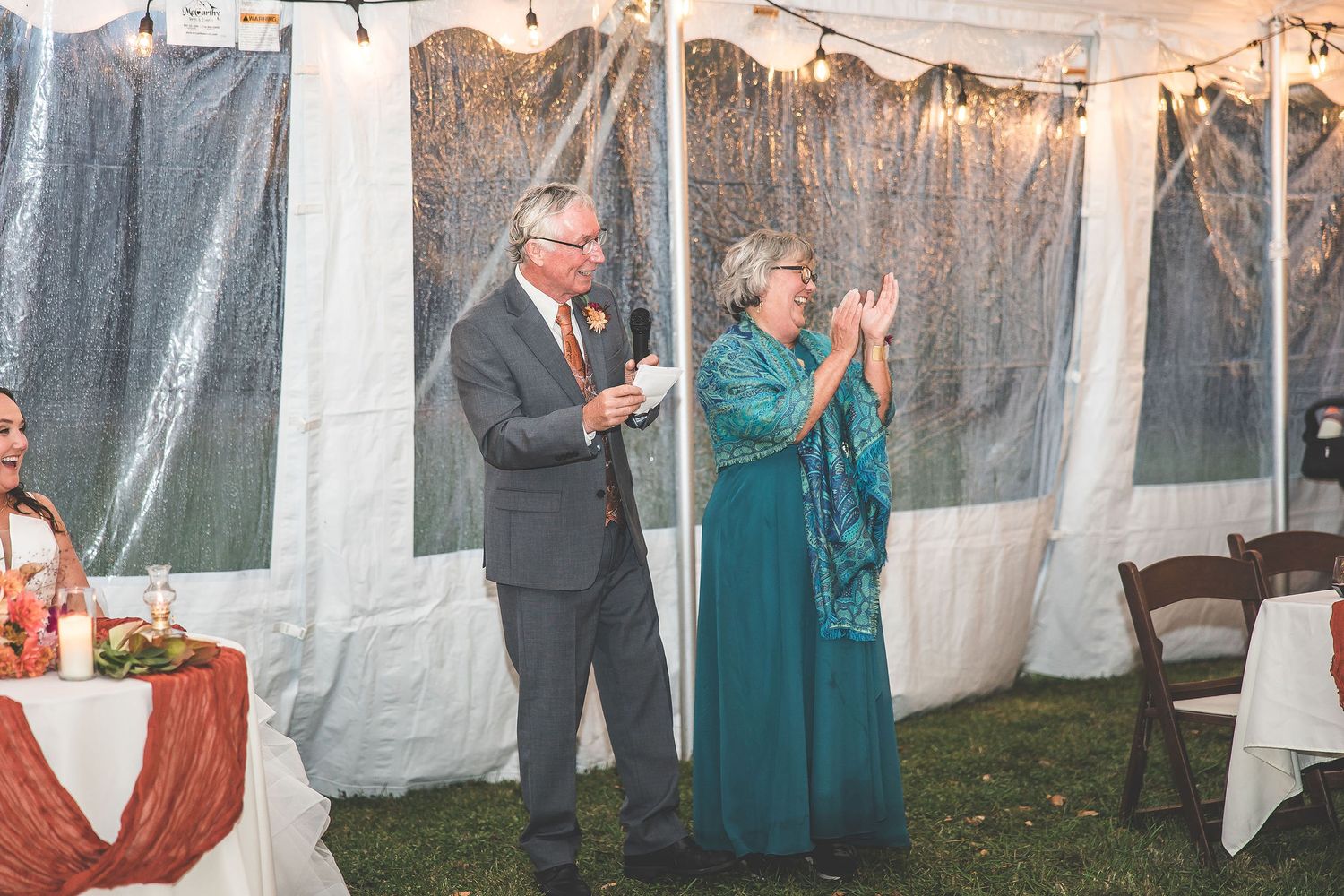 Wedding reception space with hanging lights and white drapery creating intimate atmosphere.