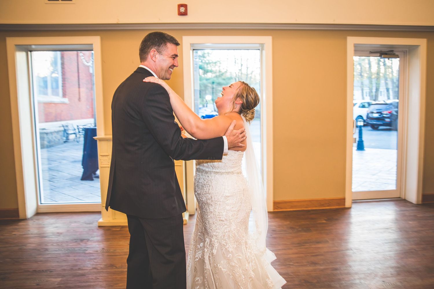 Bright indoor wedding venue with large windows and hardwood floors.