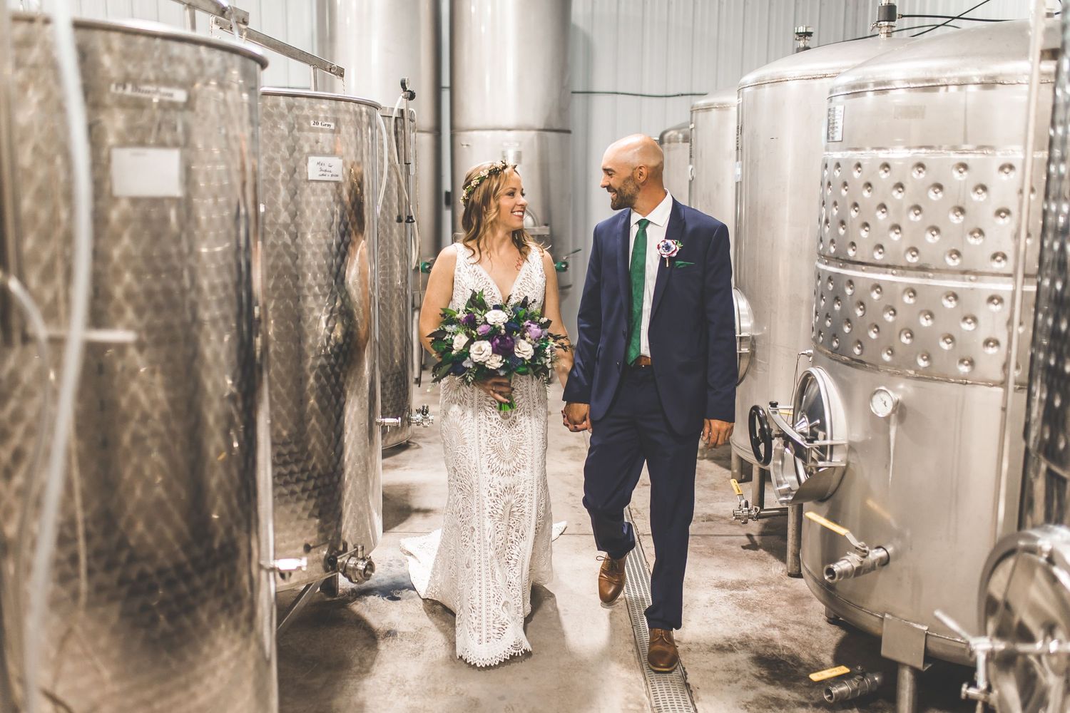 Elegant wedding photos taken among industrial wine fermentation tanks.