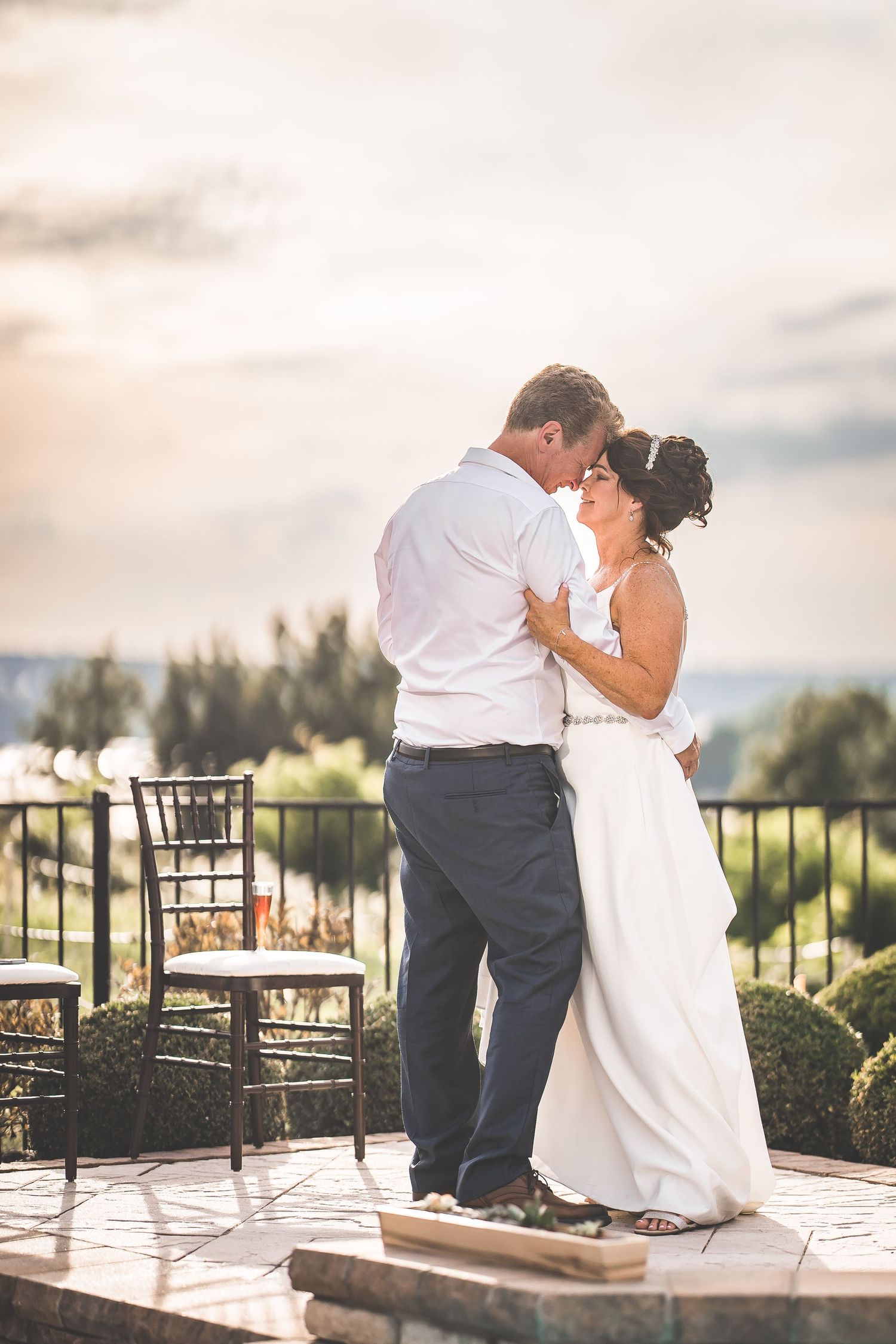 Intimate wedding dance moments captured on an outdoor terrace at dusk.