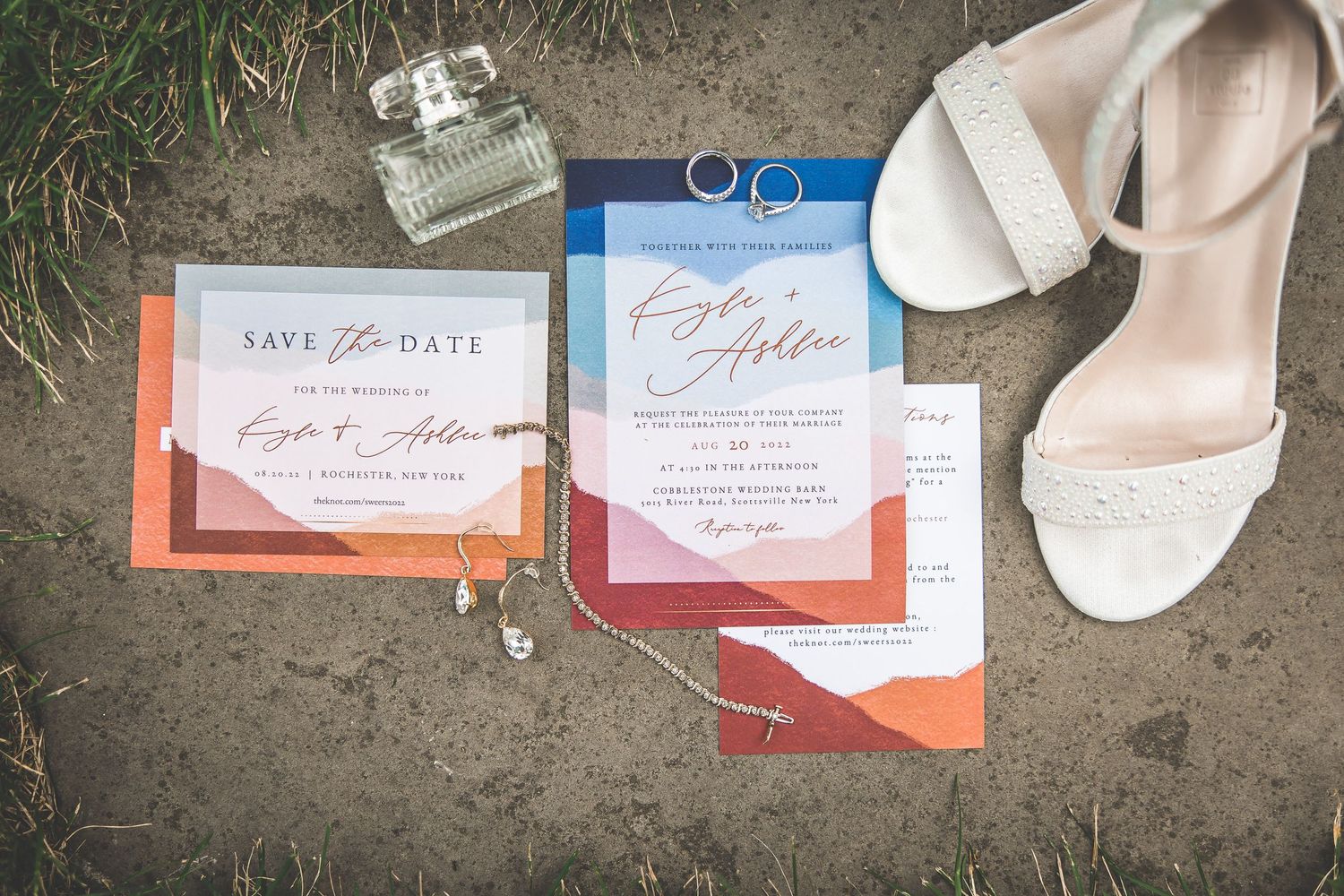 Wedding details including invitations, rings, perfume bottle and blush bridal shoes.
