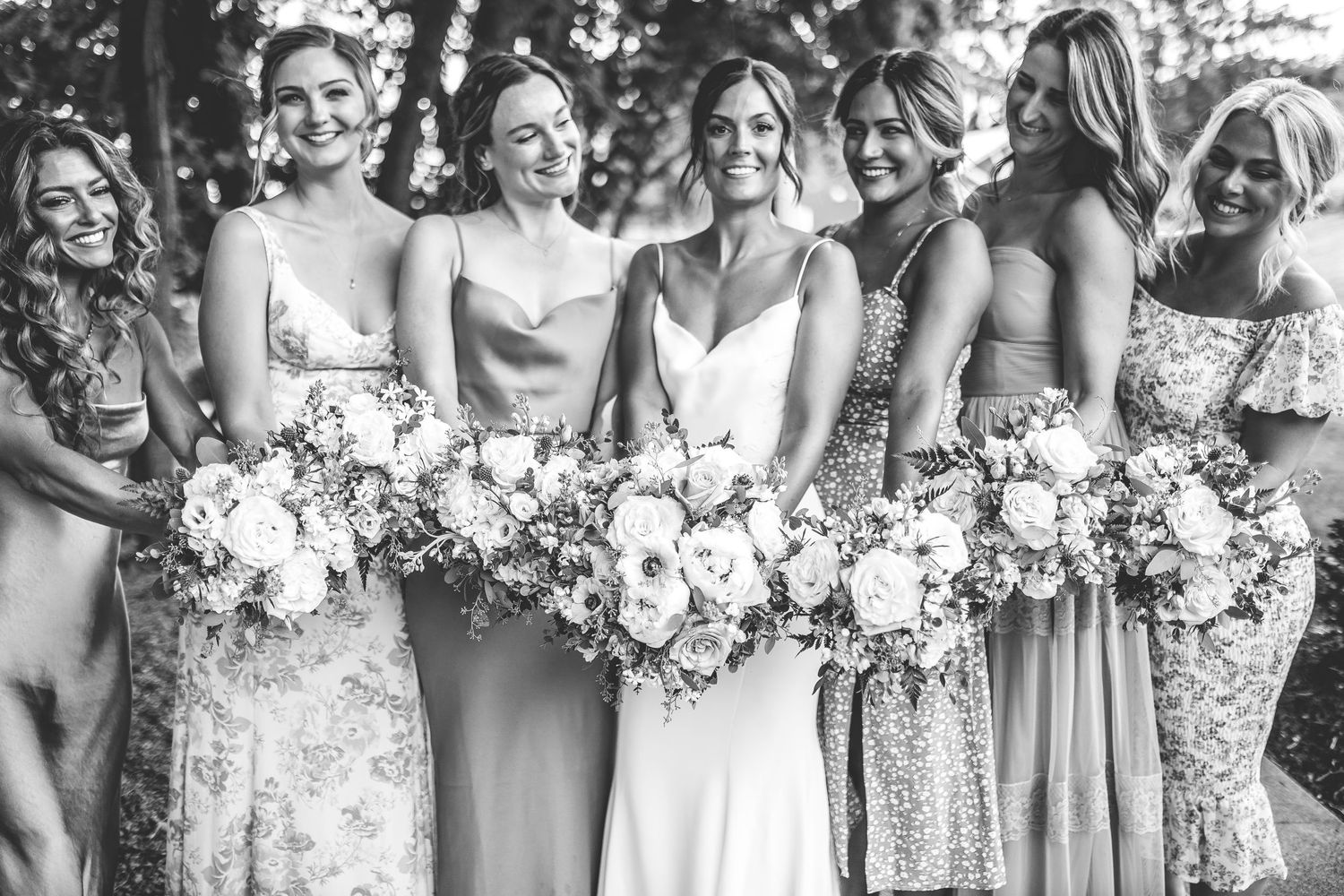 Black and white photo of bridesmaids laughing together during wedding party portraits.