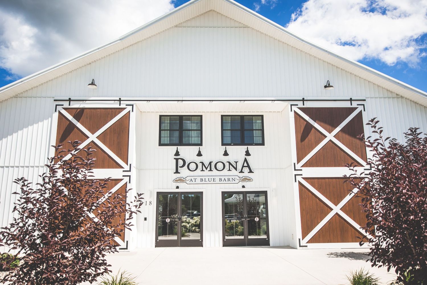 White barn wedding venue exterior with cross details and blue sky.