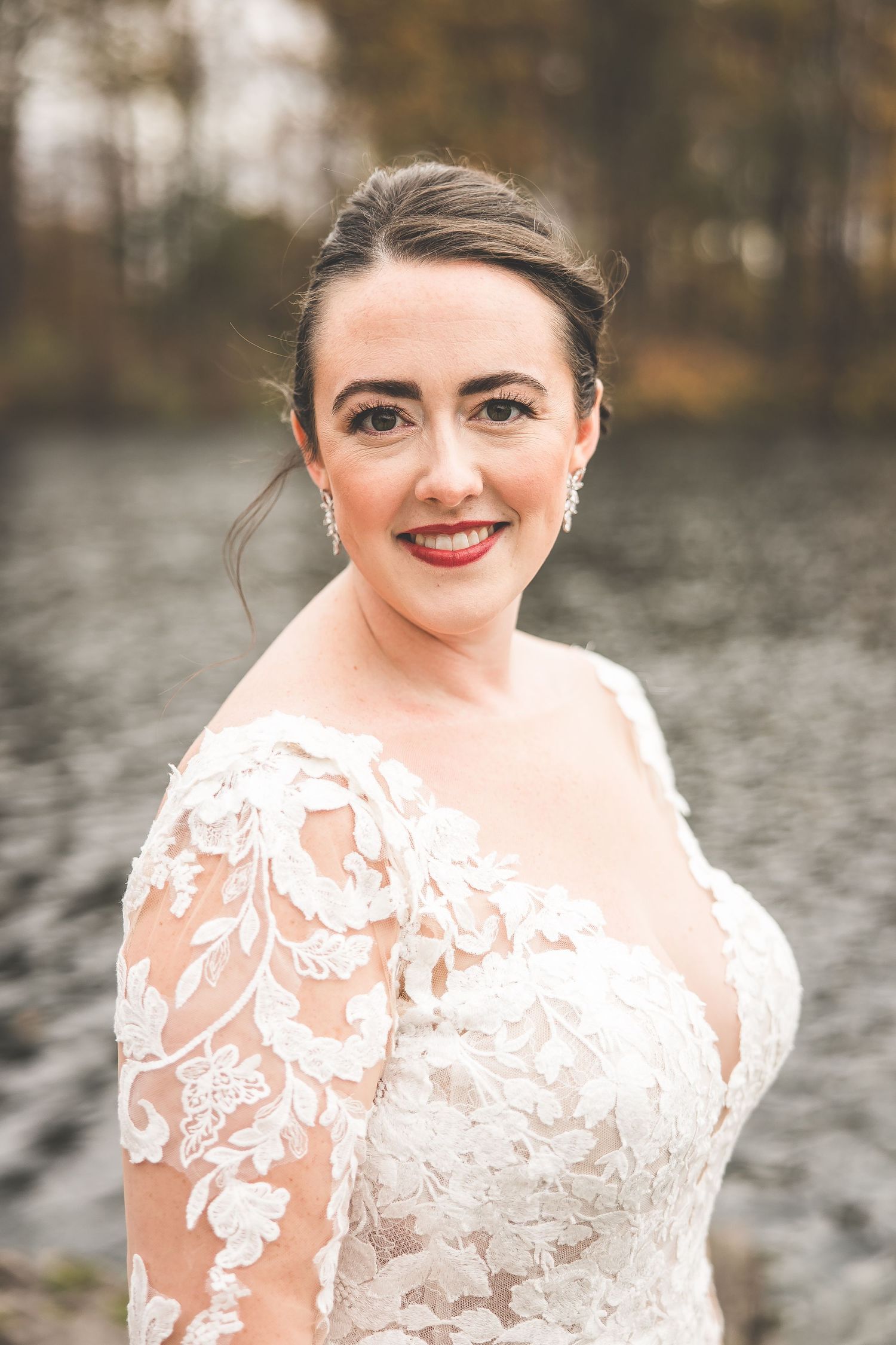 Portrait series showing bride in detailed lace wedding gown against lake backdrop.