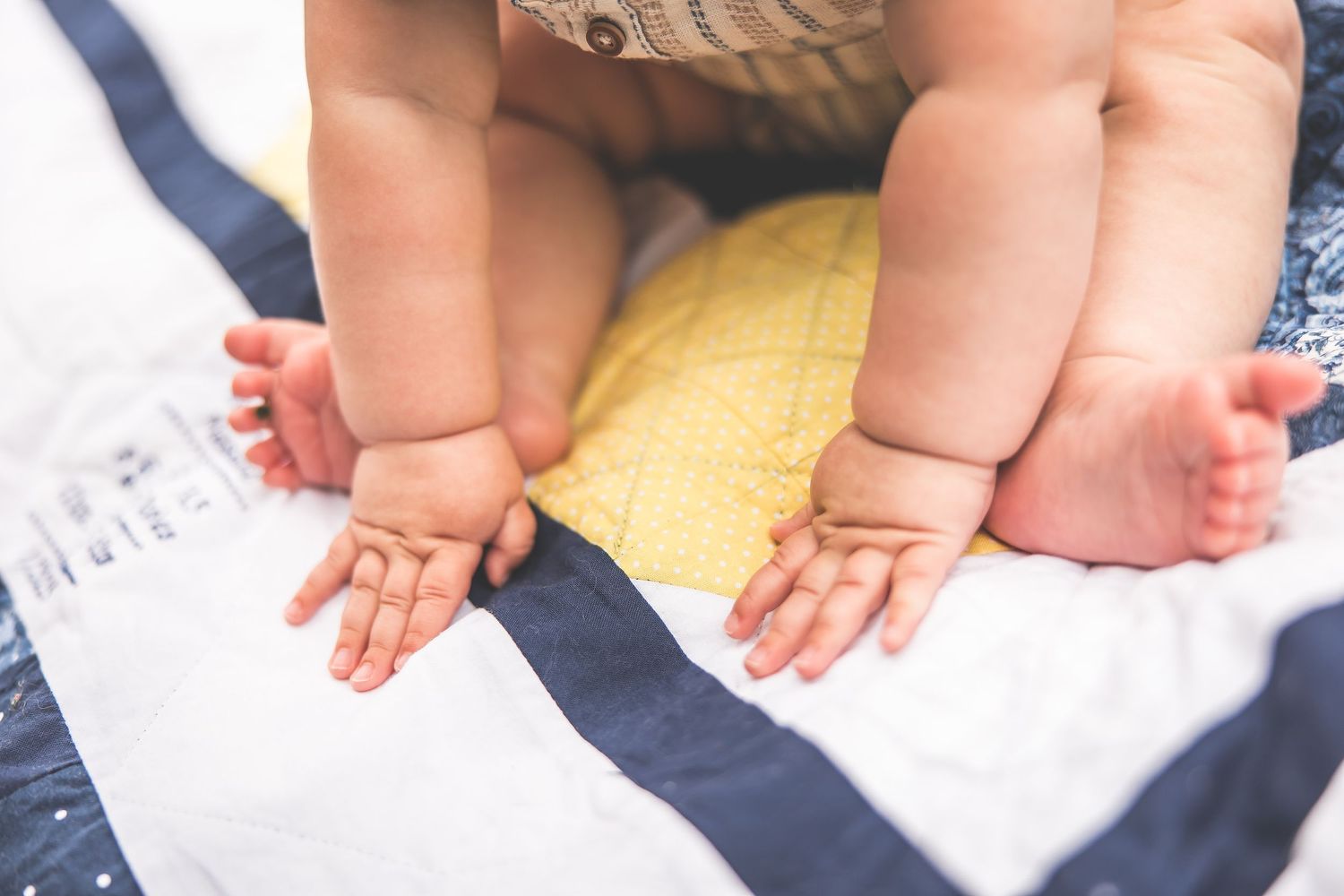 Close-up view of small bare feet resting on a white blanket during an outdoor photoshoot.