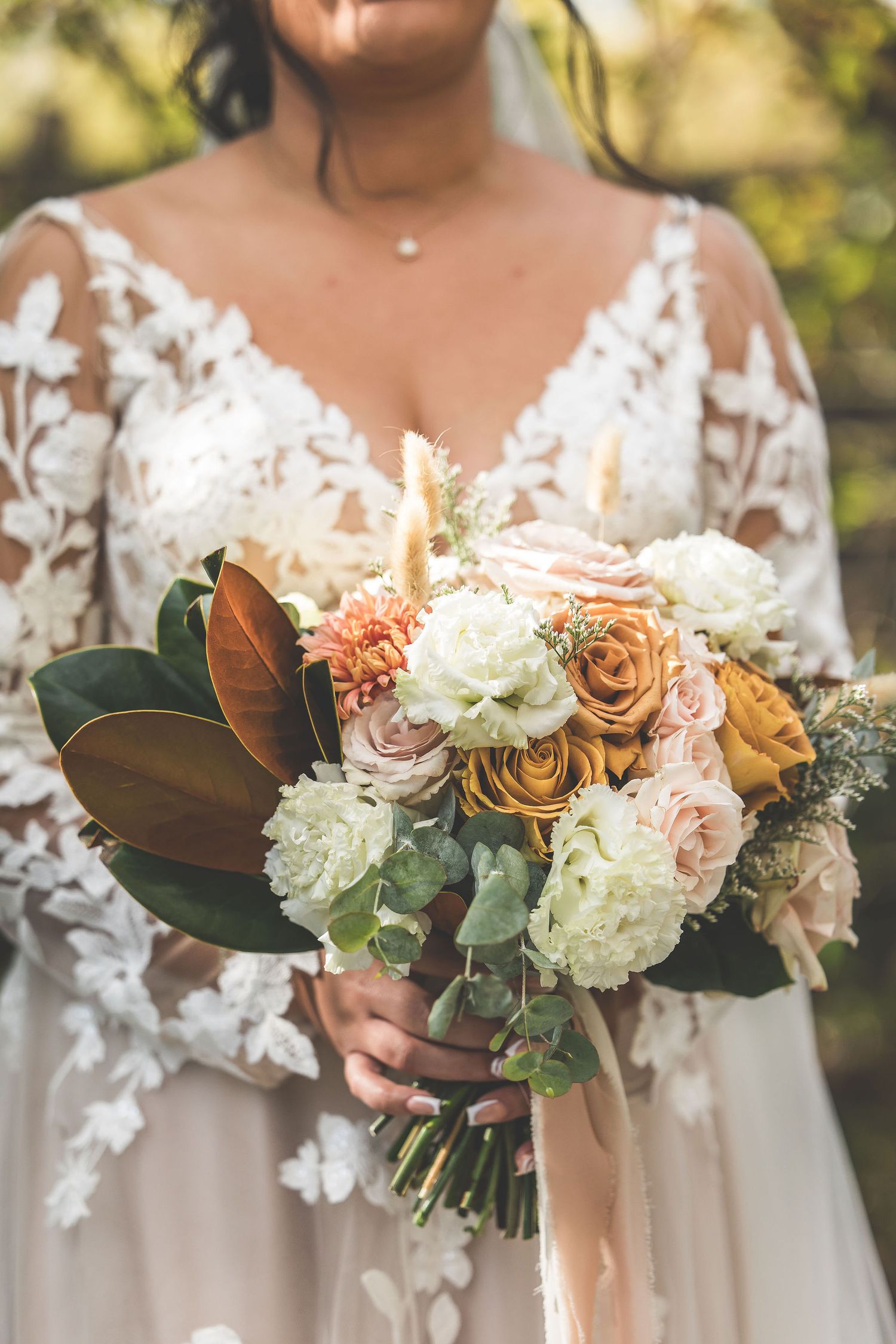 Elegant bridal bouquets featuring white and peach roses with magnolia leaves.