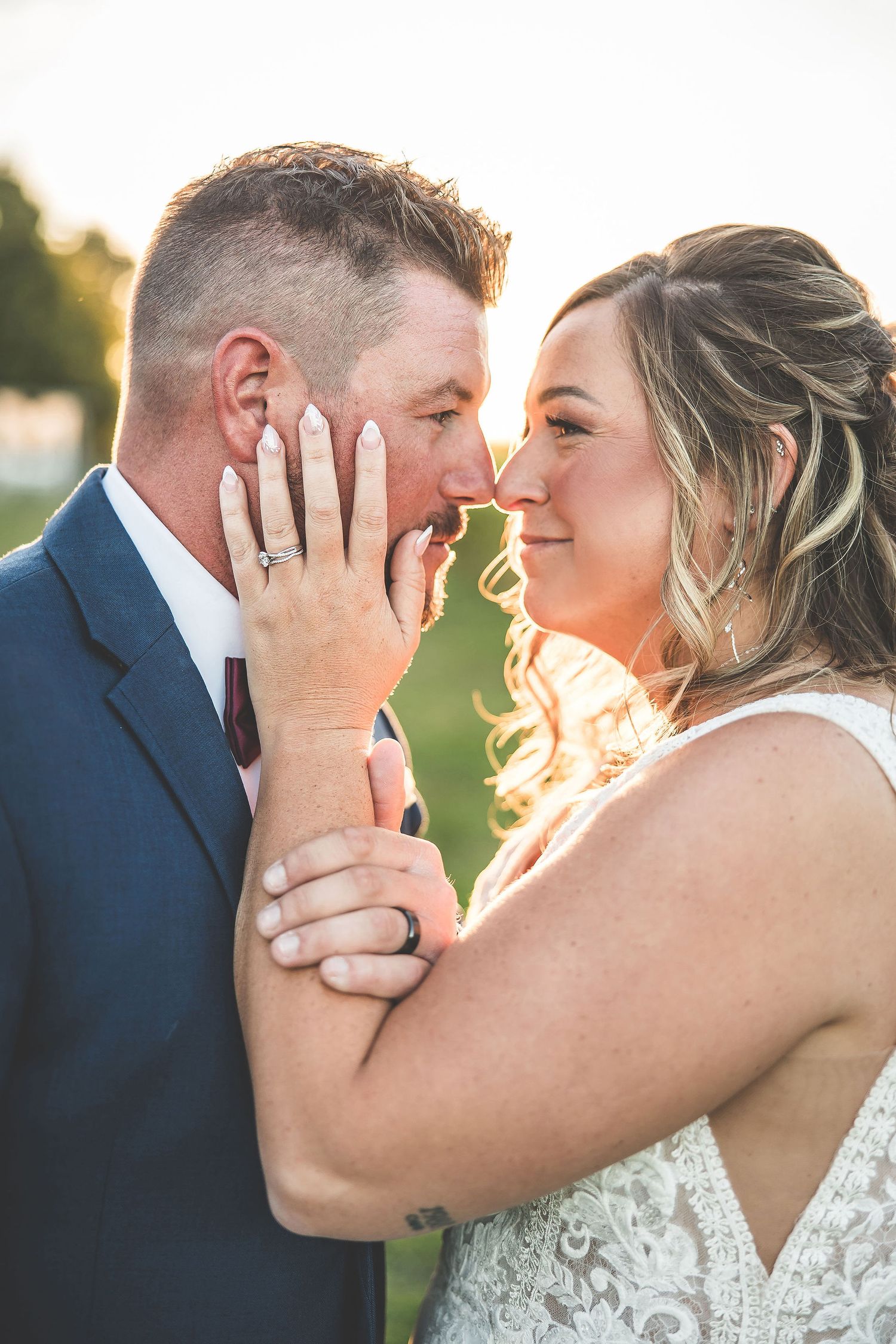 Intimate wedding couple portrait with golden sunlight and natural outdoor setting.