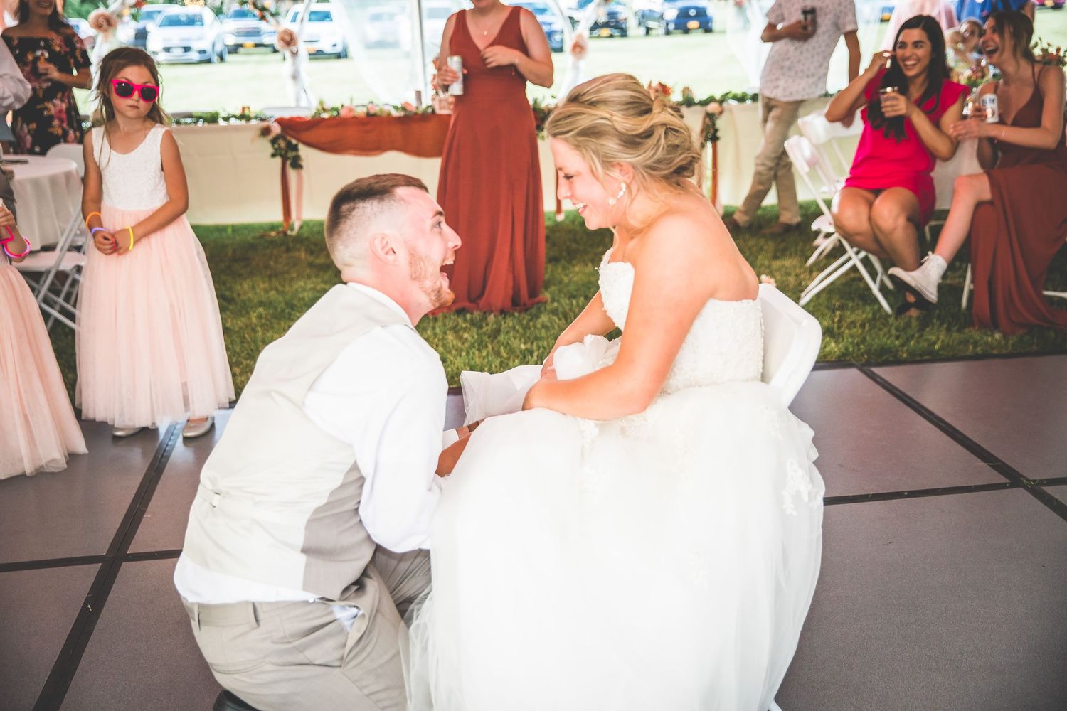 Wedding party members dancing in a line during a fun reception celebration.