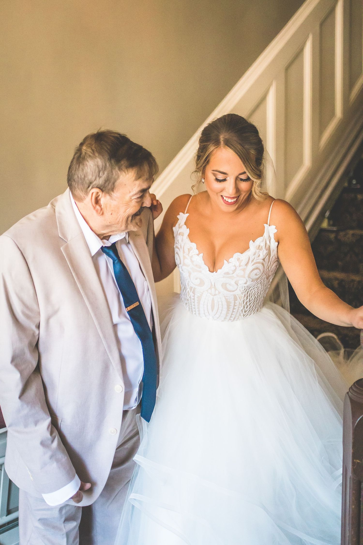 Sweet moment between young child and bride in white dress.