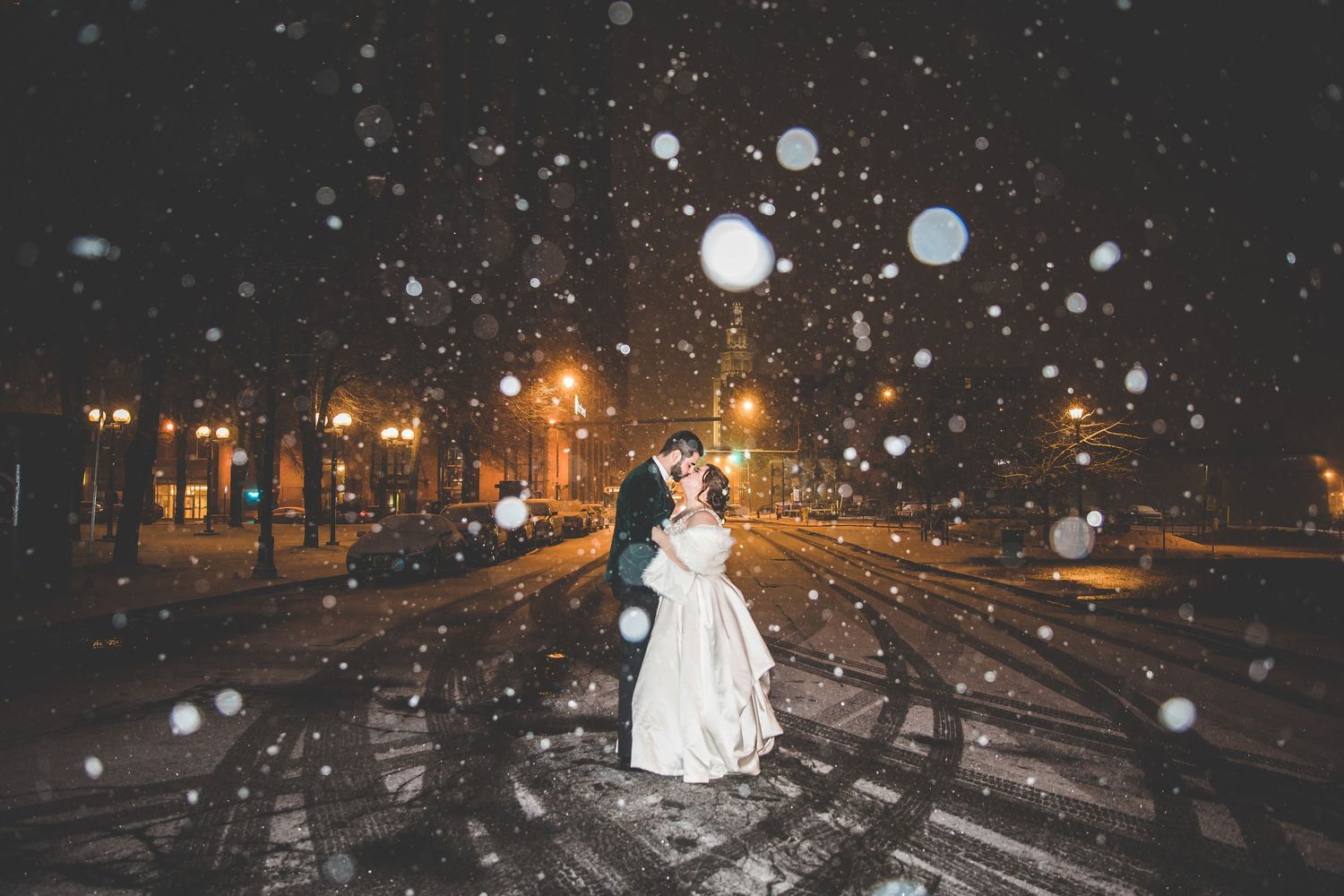 Snowy nighttime wedding scene outside with glowing lights creating a romantic winter atmosphere.
