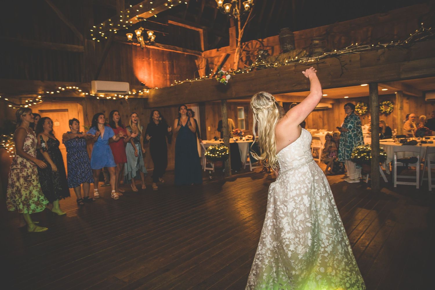 Wedding reception dance party with guests celebrating on a dimly lit dance floor.