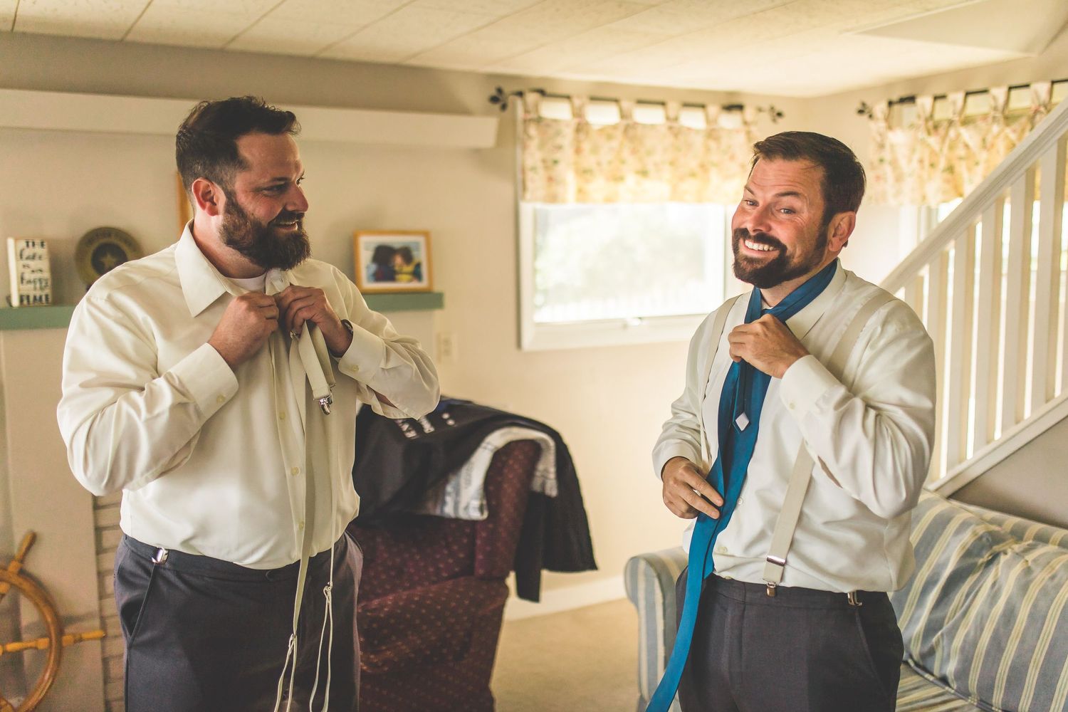 Groomsmen getting ready and helping each other with formal attire.
