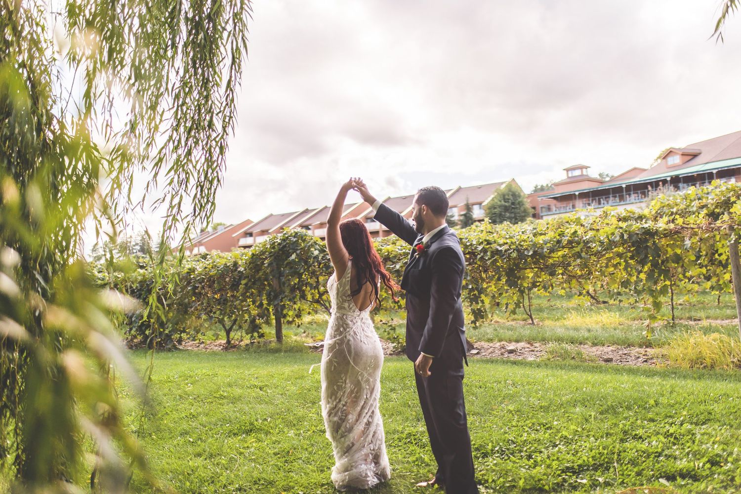 Wedding couple dances together in vineyard landscape.