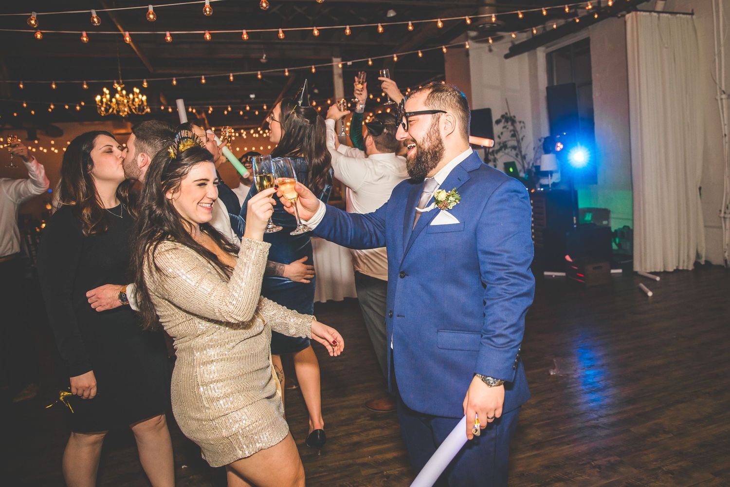 Wedding reception venue decorated with string lights and blue accent lighting.