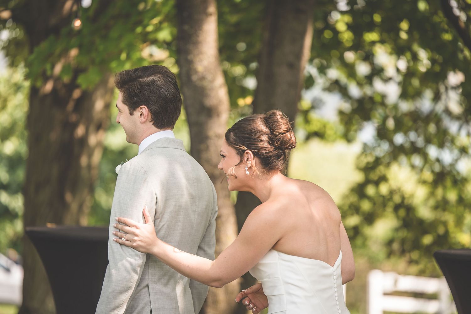 Romantic wedding photos captured in a garden setting with natural sunlight filtering through trees.