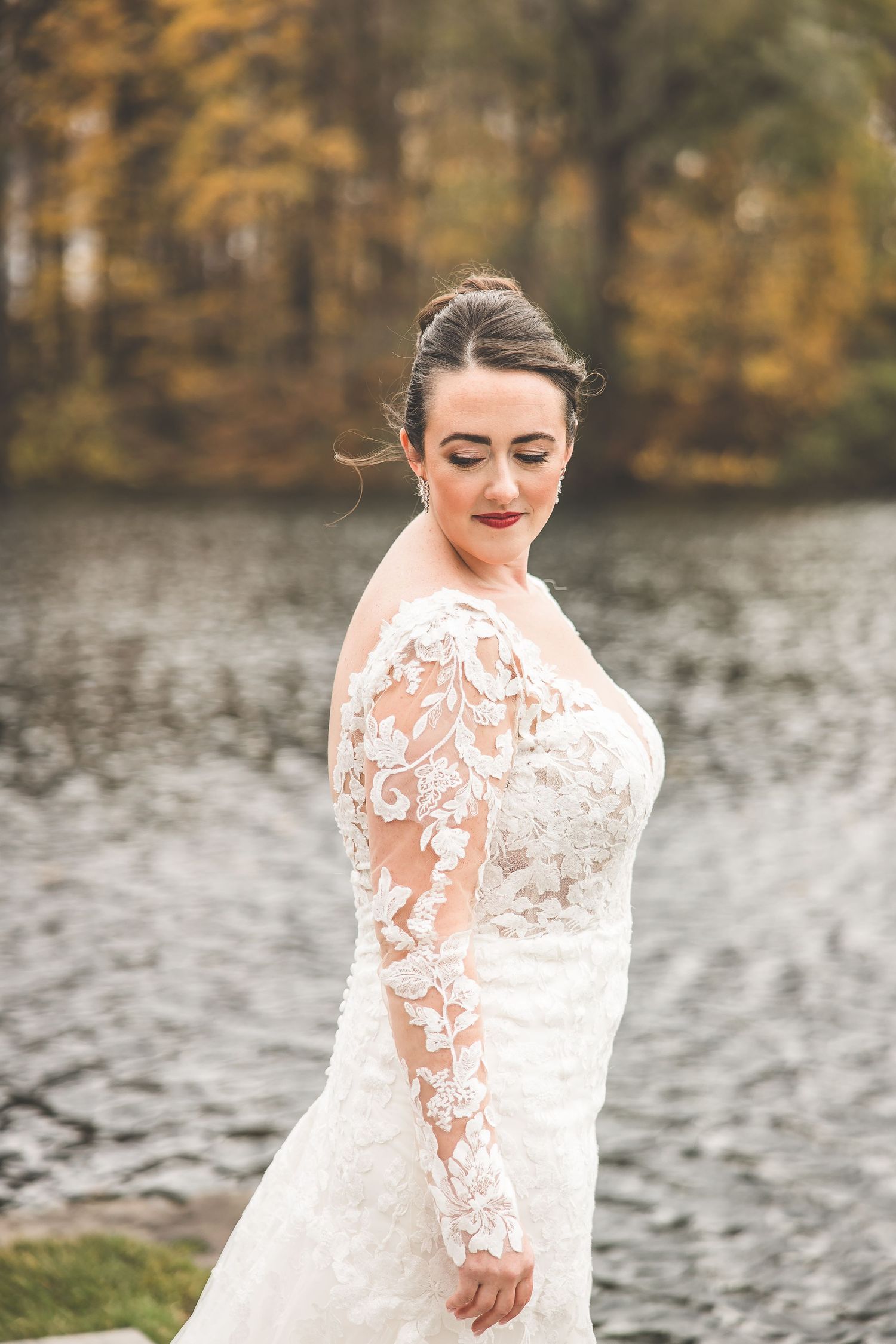 Close-up shots of intricate lace details on wedding dress by lakeside.