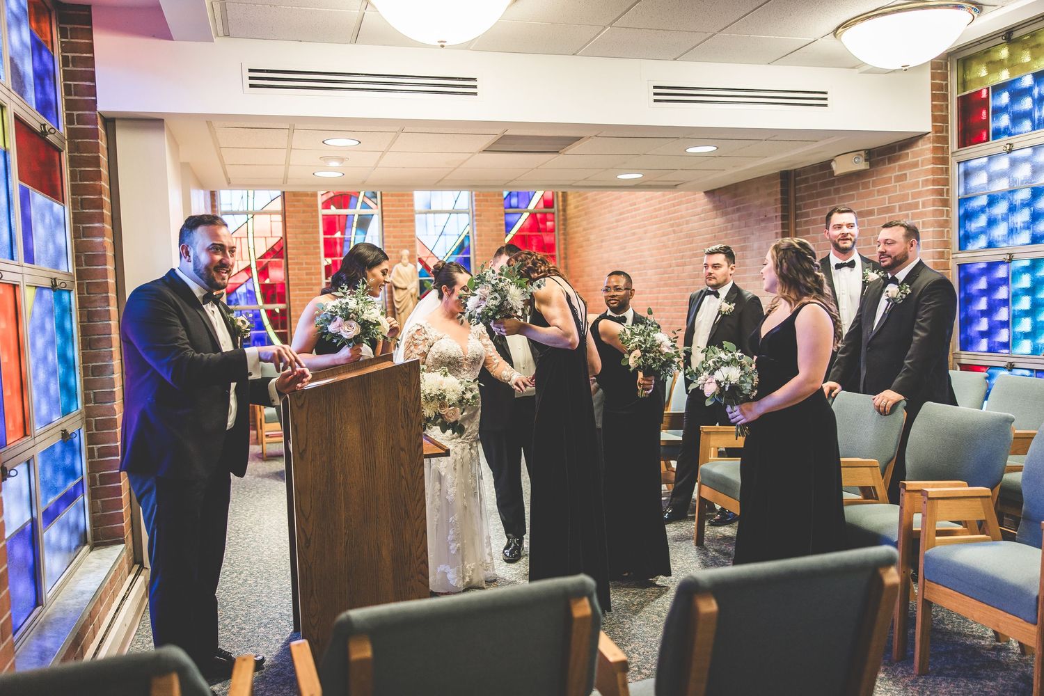 Wedding celebration in church reception hall with stained glass windows and festive atmosphere.