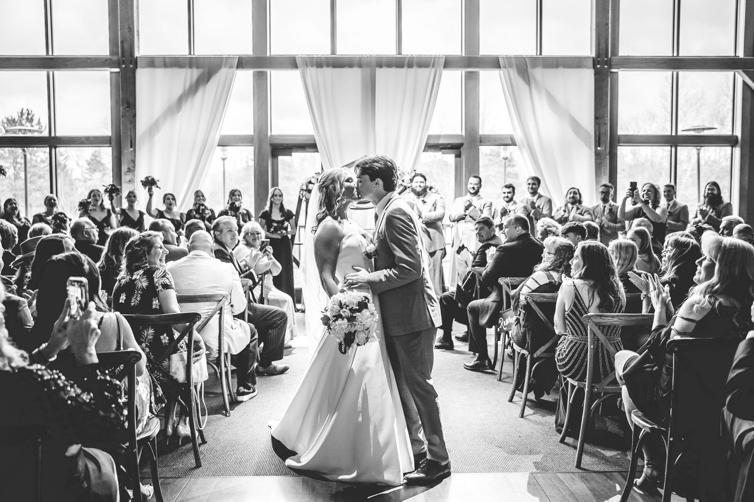 Panoramic black and white photos capture the full scope of an indoor wedding ceremony.
