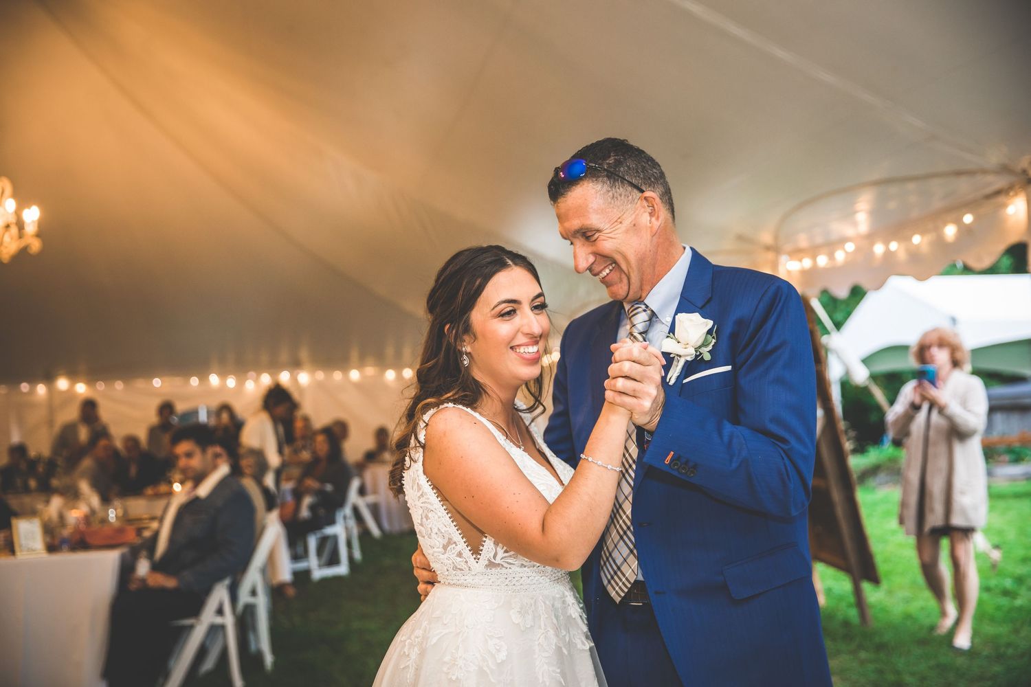 Candid moments of a couple's first dance captured in warm lighting at their reception.