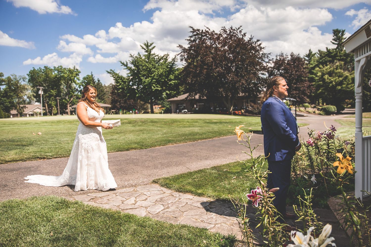 Wedding couple having their first look moment in a sunny garden setting.