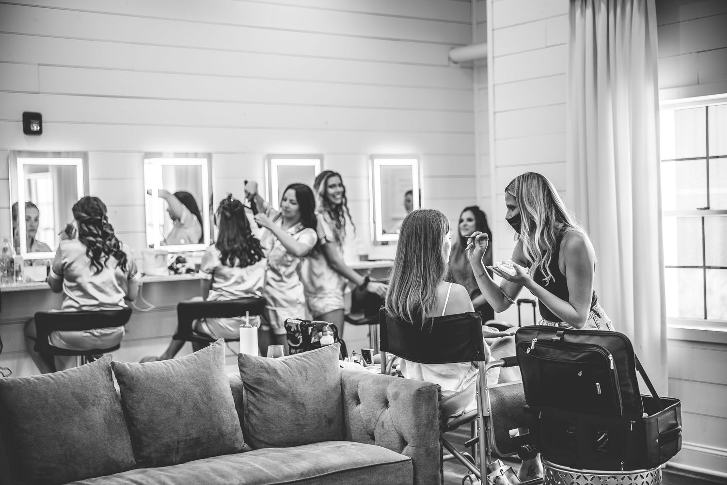 Group getting ready in a cozy room with white curtains and gray couch.