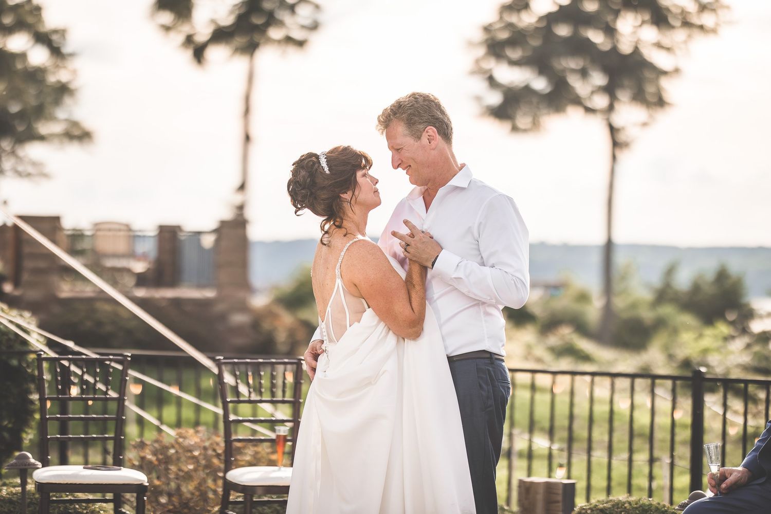 Romantic sunset wedding portraits on an outdoor terrace with scenic views.