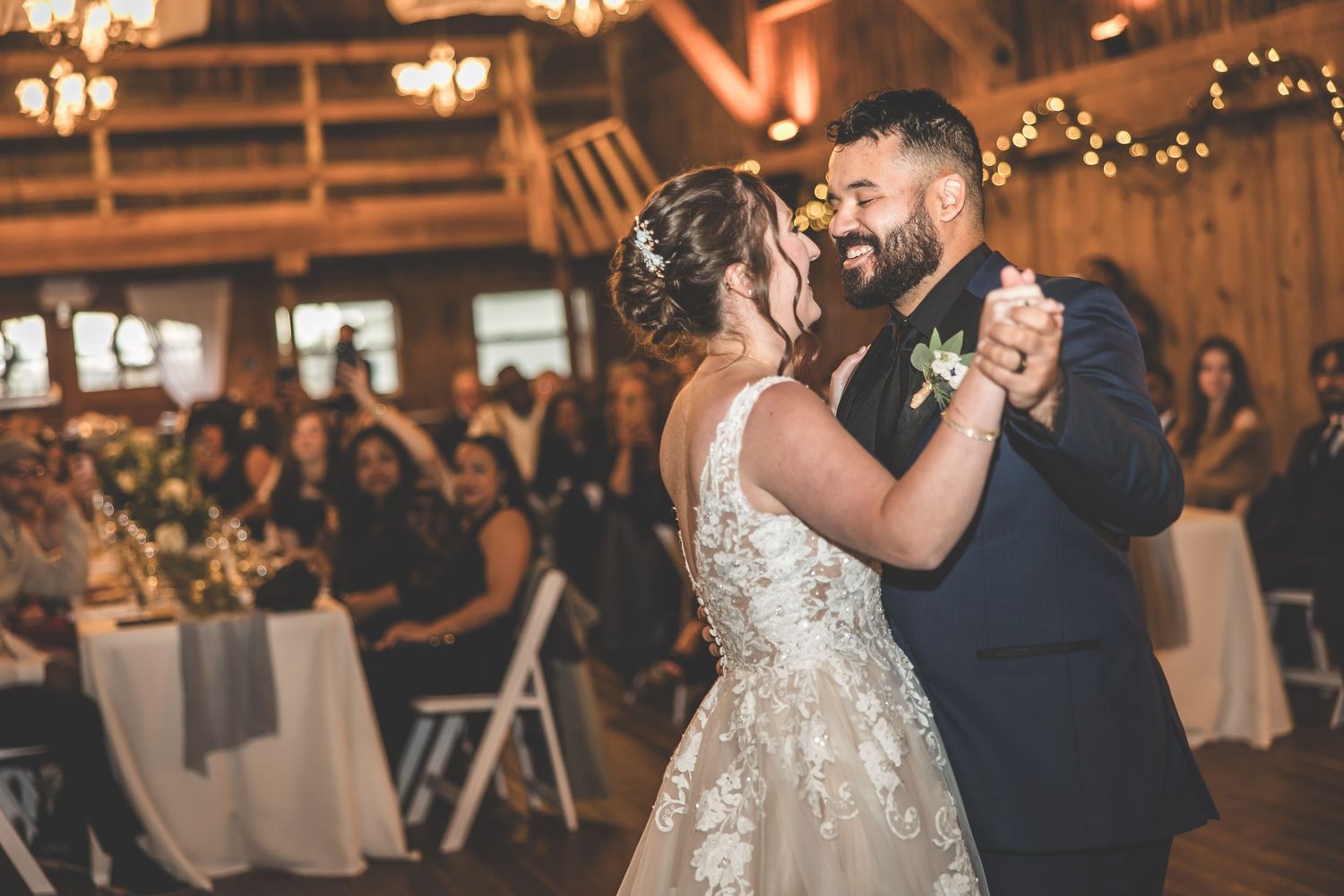 Wedding reception in a rustic barn venue with warm lighting and elegant decor.