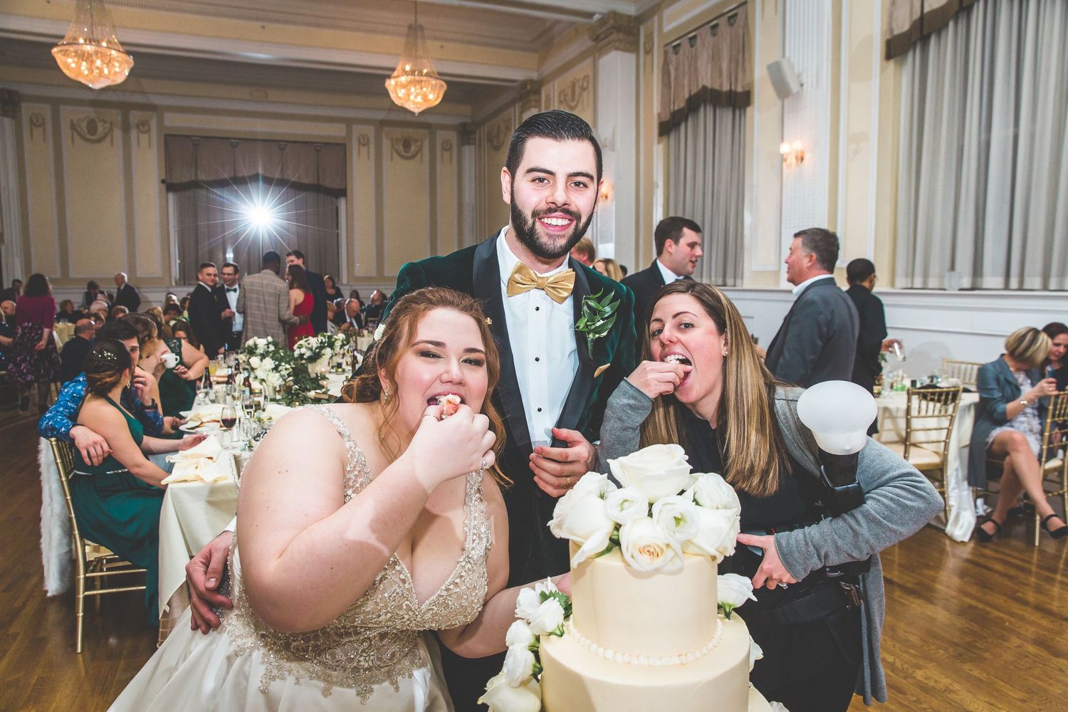 Wedding reception candid moments captured in an elegant ballroom with crystal chandeliers.