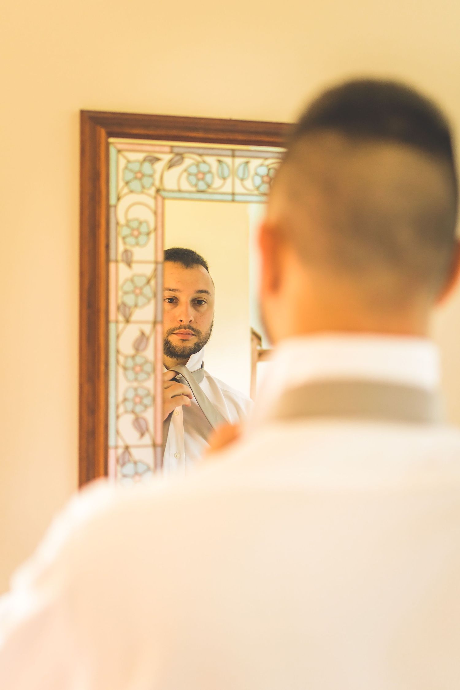 Soft yellow-tinted getting ready scene with decorative mirror and morning light.