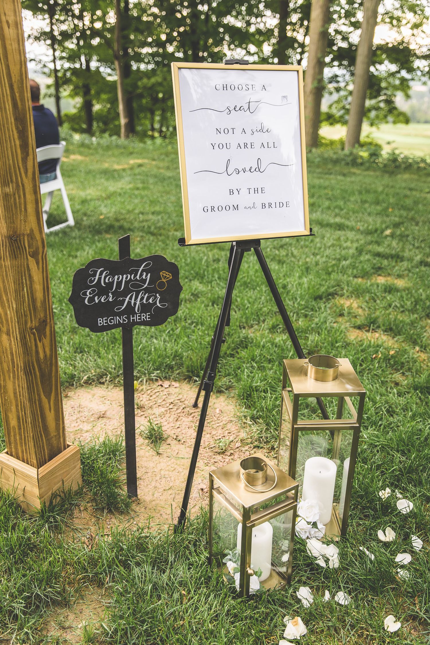 Rustic wooden signs with wedding messages displayed on grass.